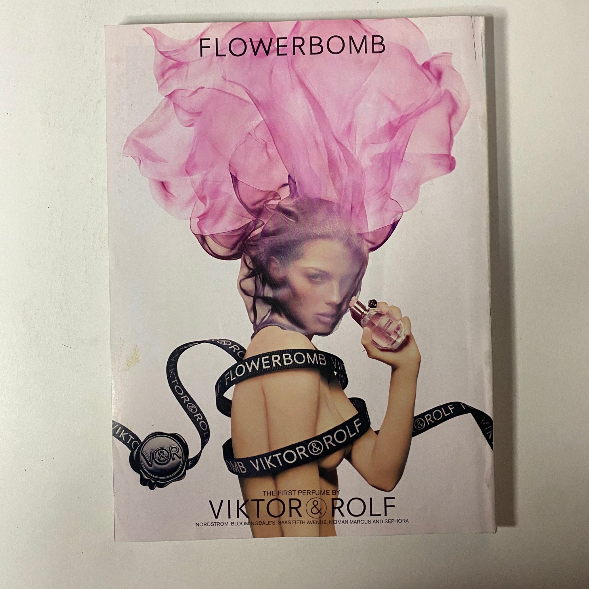 Perfume advertisement for Viktor & Rolf Flowerbomb from Vogue Magazine December 2013, featuring a model with an artistic design of pink fabric, showcasing luxury fragrance.
