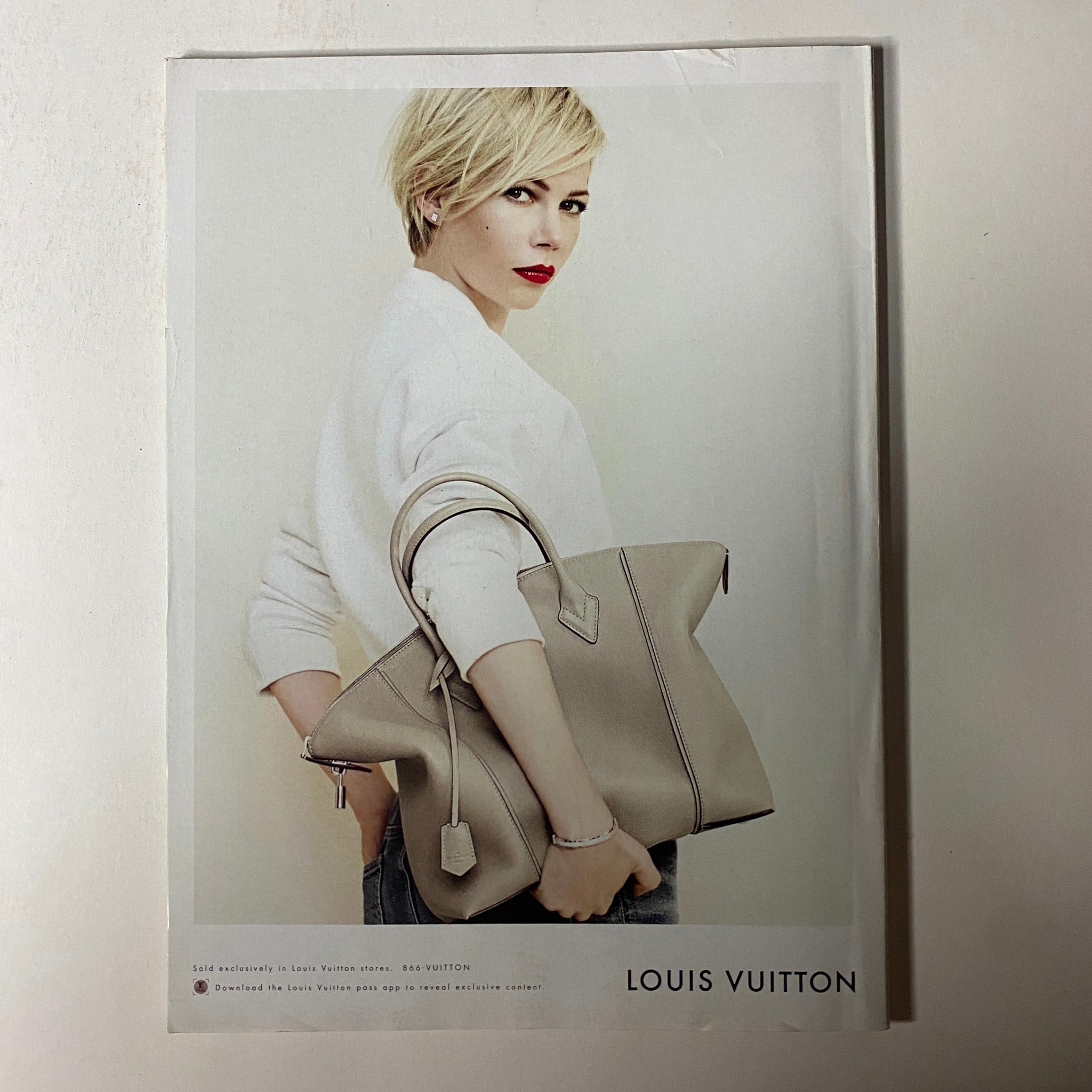 Advertisement from Vogue Magazine July 2014 featuring a model with a stylish Louis Vuitton bag, emphasizing contemporary luxury fashion.