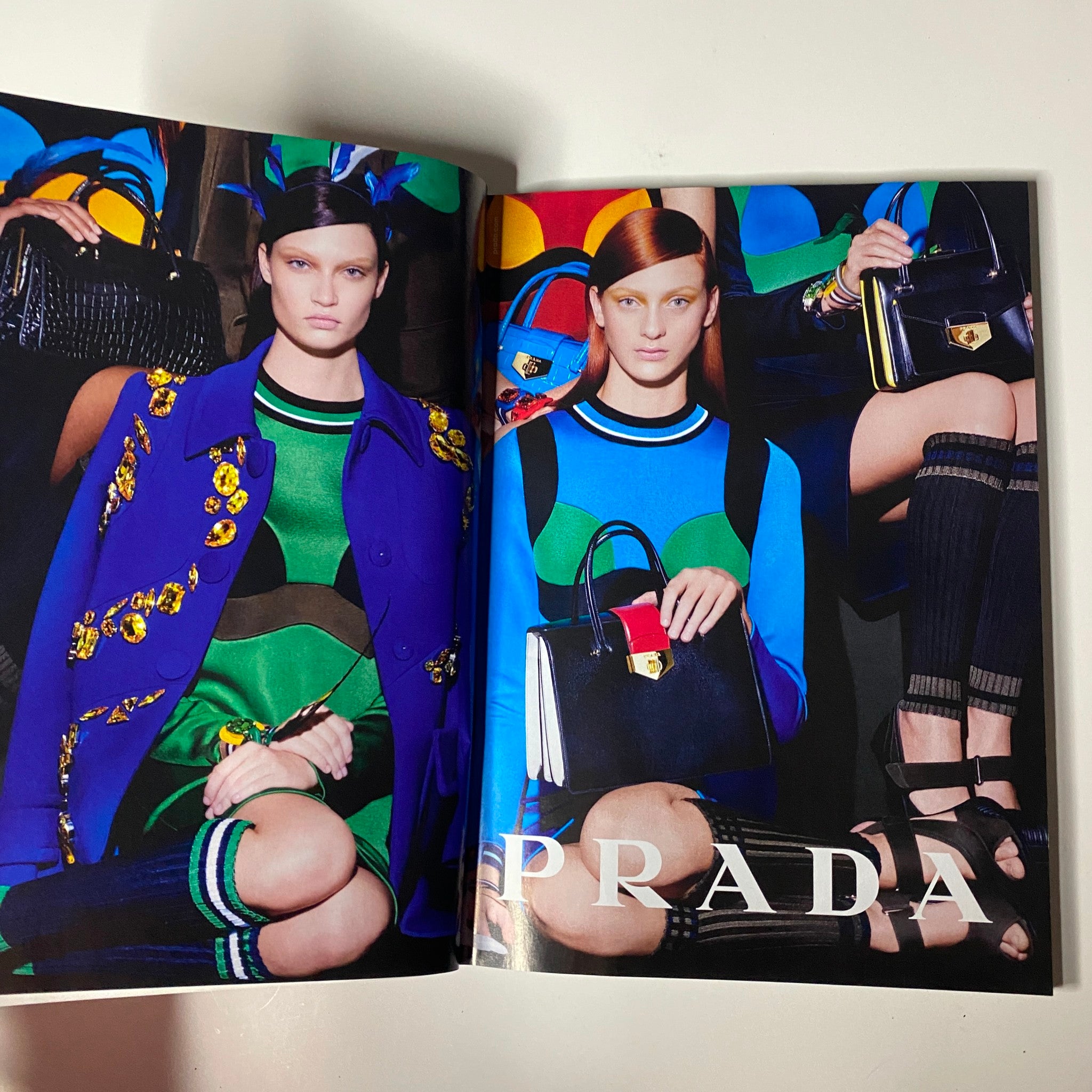 Inside Vogue Magazine February 2014, a striking Prada fashion editorial presents models in vibrant outfits and stylish handbags, highlighting the latest trends in luxury fashion.
