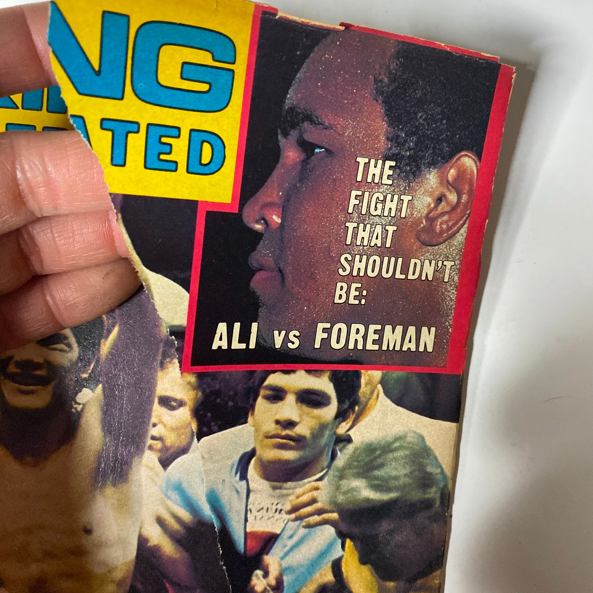 Cover detail from Boxing Illustrated Magazine November 1976 featuring Muhammad Ali and George Foreman with the caption 'THE FIGHT THAT SHOULDN'T BE: ALI vs FOREMAN'.