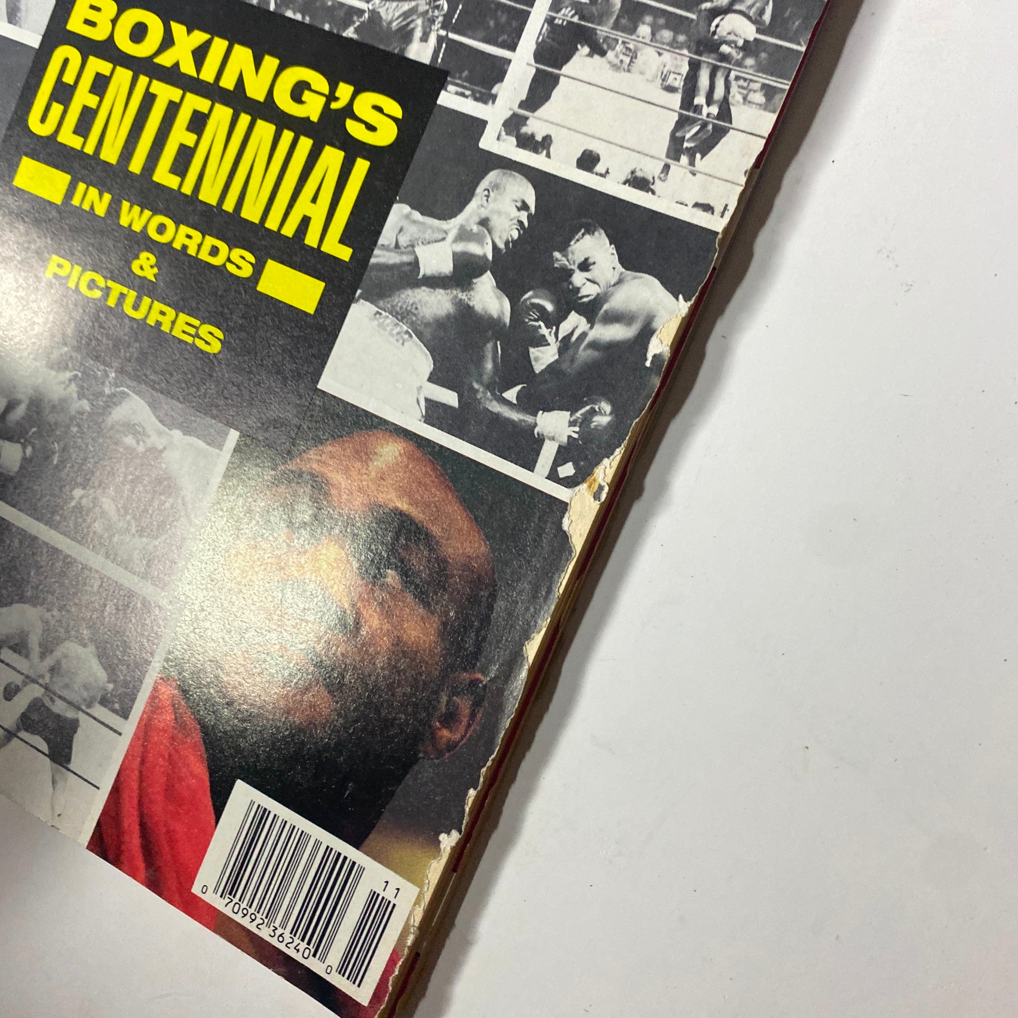 Close-up of the side of Boxing Illustrated Magazine November 1992, highlighting Boxing's Centennial in Words & Pictures with vivid photos of famous boxers and the magazine's well-worn edges.