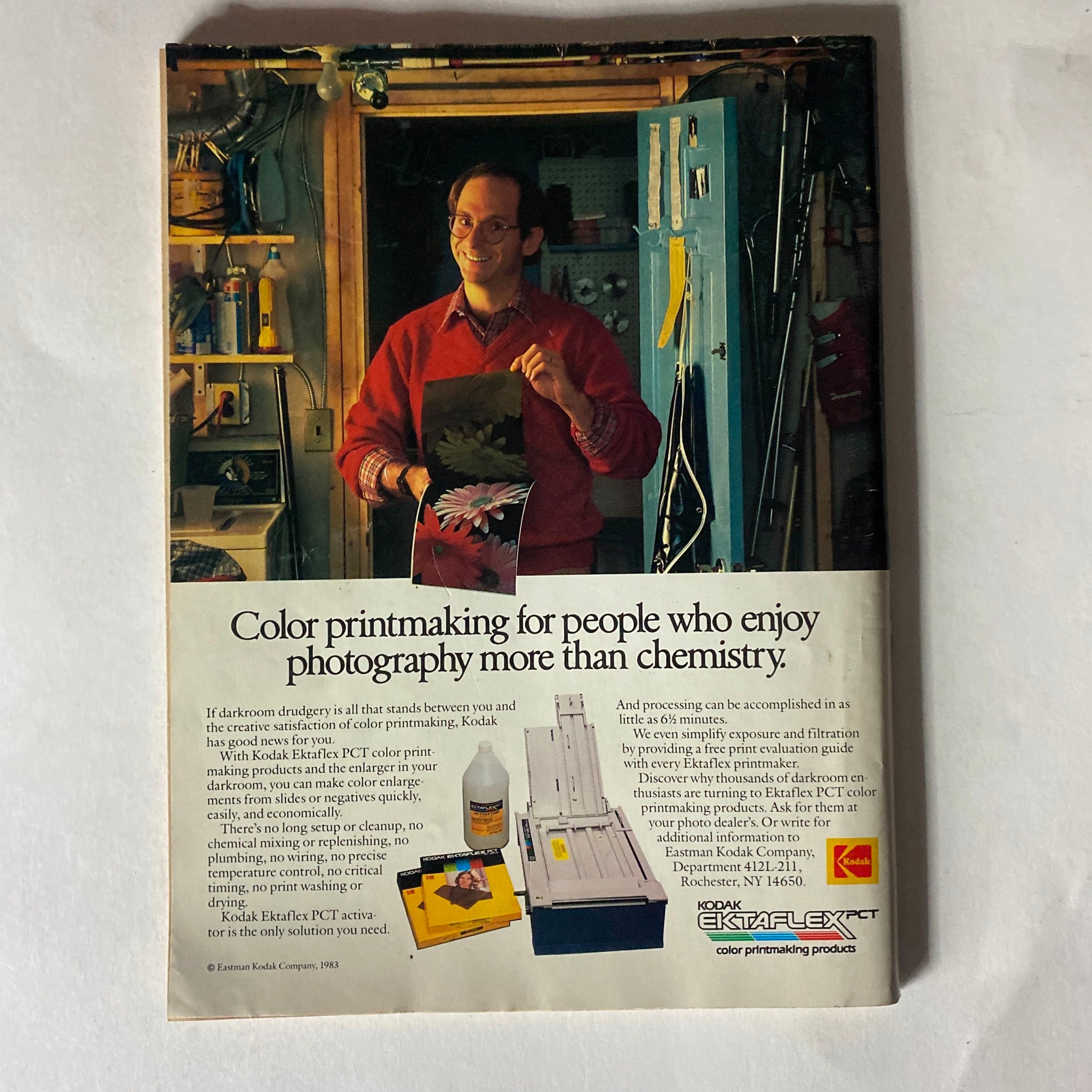 Back cover of the January 1984 American Photographer Magazine. An advertisement for Kodak Ektaflex PCT color printing products with a smiling individual in a darkroom holding up printed photos.