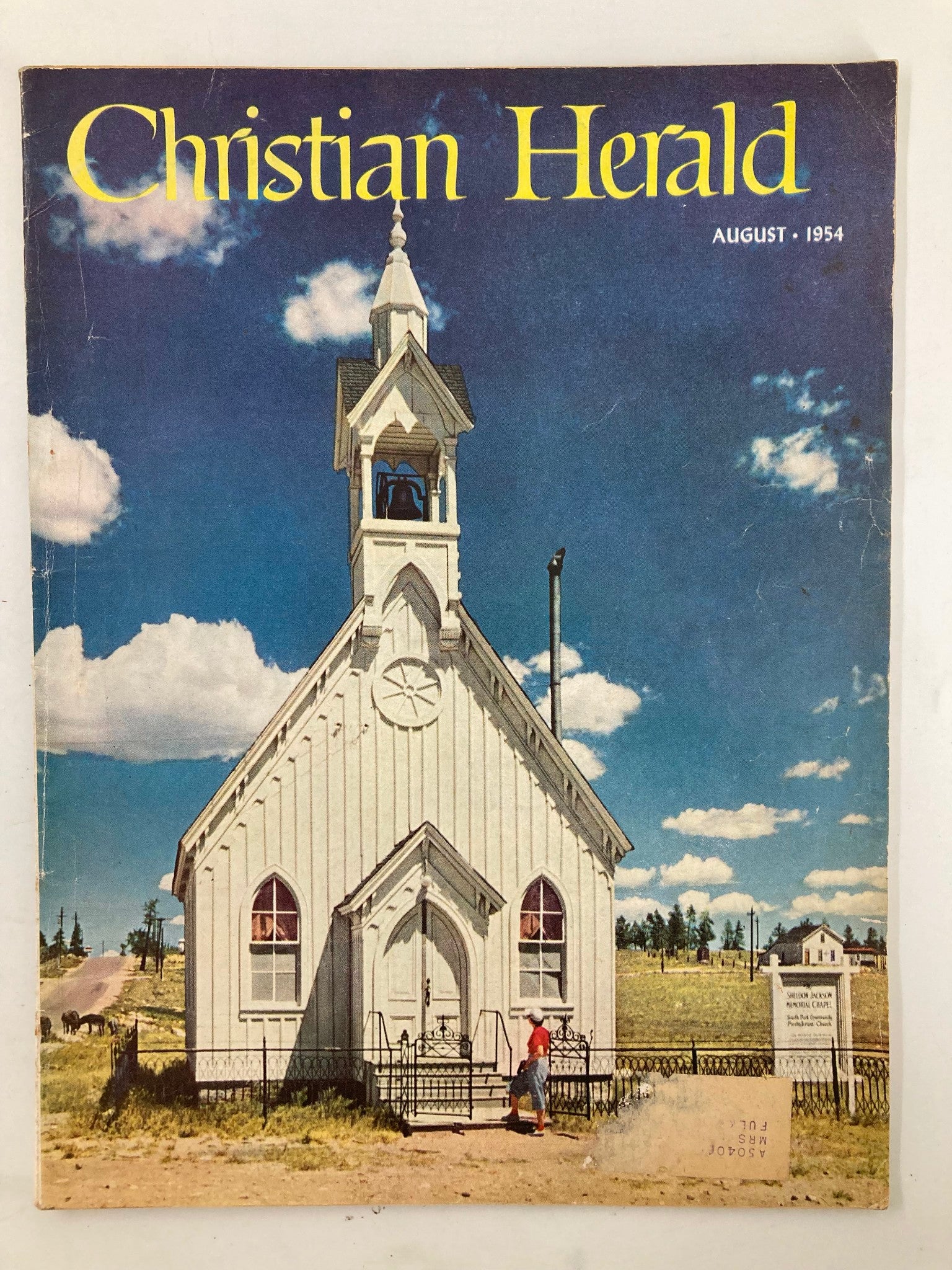 Cover of the VTG Christian Herald Magazine August 1954, featuring a historic church at Fairplay, Colorado with blue skies and clouds.