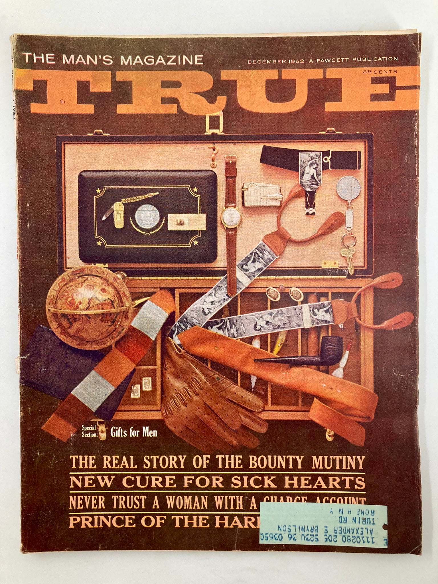 Cover of TRUE The Man's Magazine December 1962 featuring the title 'Never Trust A Woman with a Charge Account'. The cover displays a collection of vintage men's items, including a globe, a watch, and various accessories.