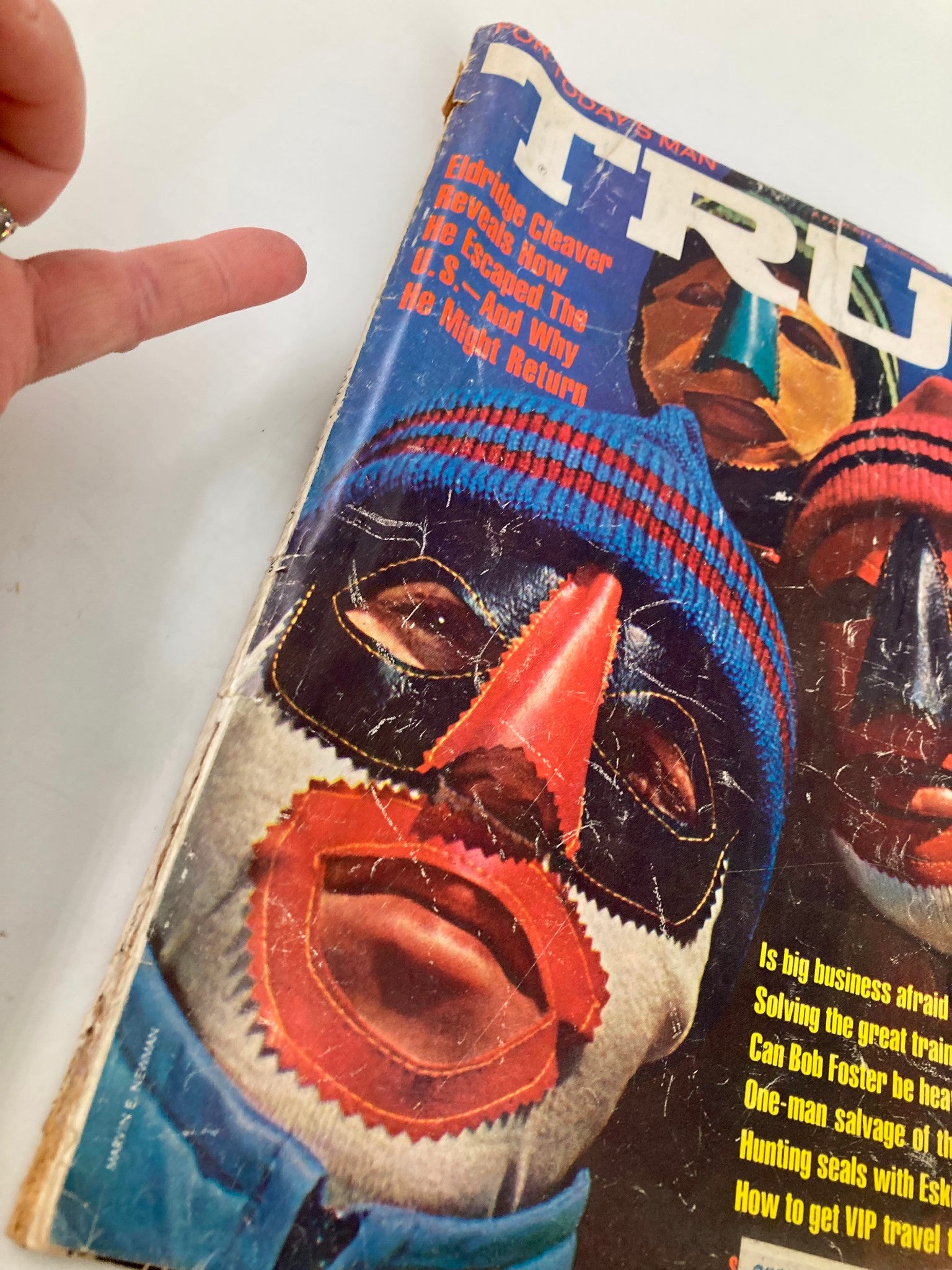 Close-up view of the cover of TRUE The Man's Magazine January 1970, titled 'Across The Top of The World', focusing on masks and the text about Eldridge Cleaver and featured stories inside the magazine.