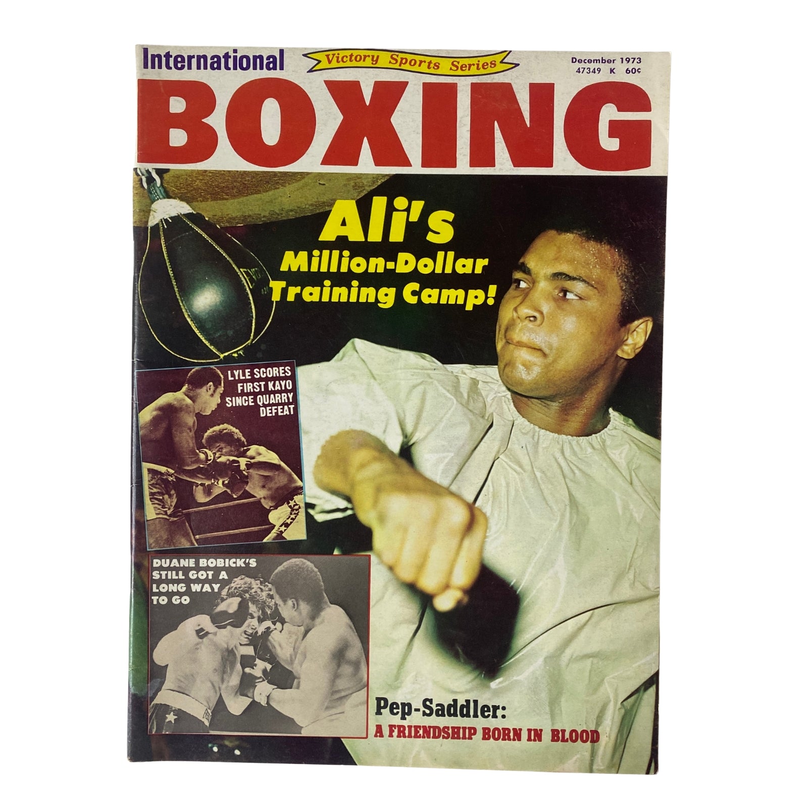 Cover of International Boxing Magazine, December 1973 featuring Muhammad Ali with the headline 'Ali's Million-Dollar Training Camp!' and other boxing news.