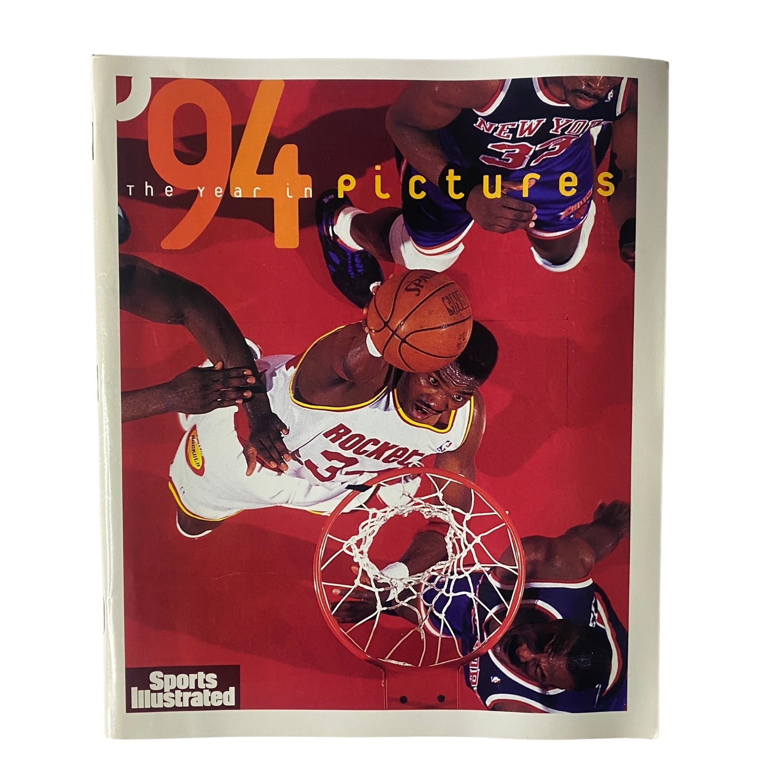 Sports Illustrated Magazine 1994 Year in Pictures featuring Hakeem Olajuwon, showcasing the Houston Rockets' NBA Championship win, with a striking overhead action shot of Olajuwon during a game.