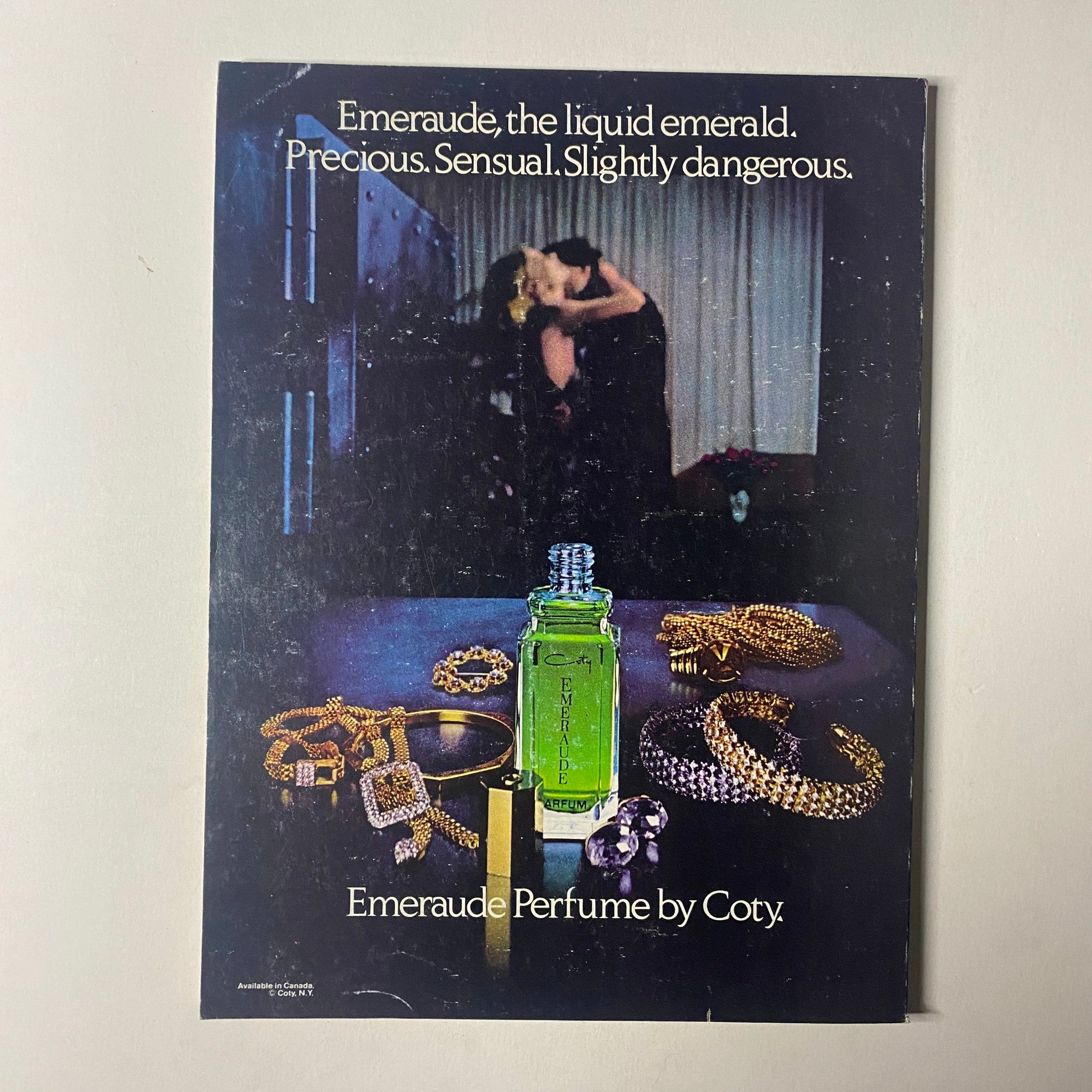 Promotional image for Emeraude perfume by Coty, showcasing a green bottle surrounded by jewelry, emphasizing the perfume's allure as described in Seventeen Magazine September 1979.