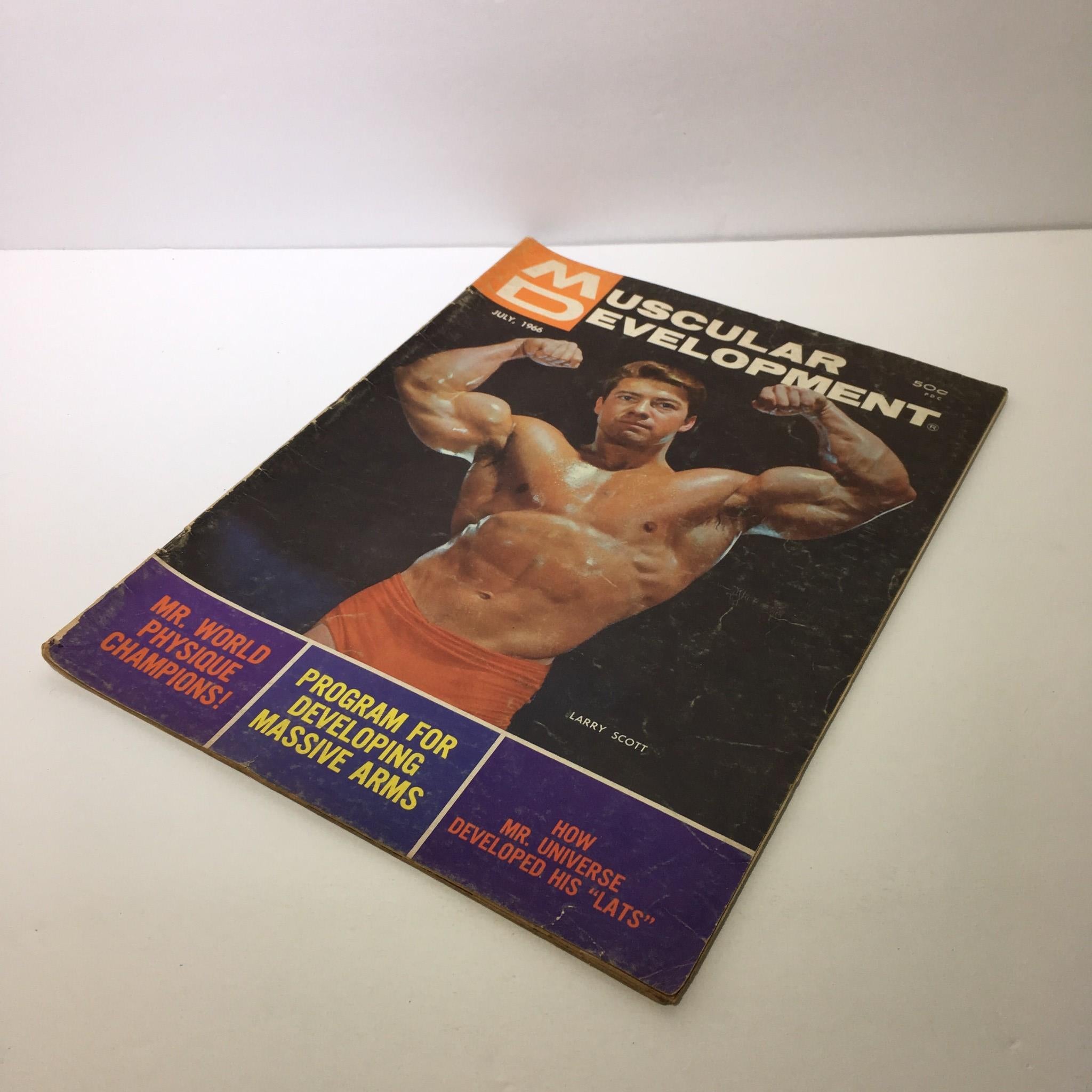 Front cover of Muscular Development Magazine, July 1966, displaying Larry Scott in a muscle pose along with headlines about bodybuilding programs.