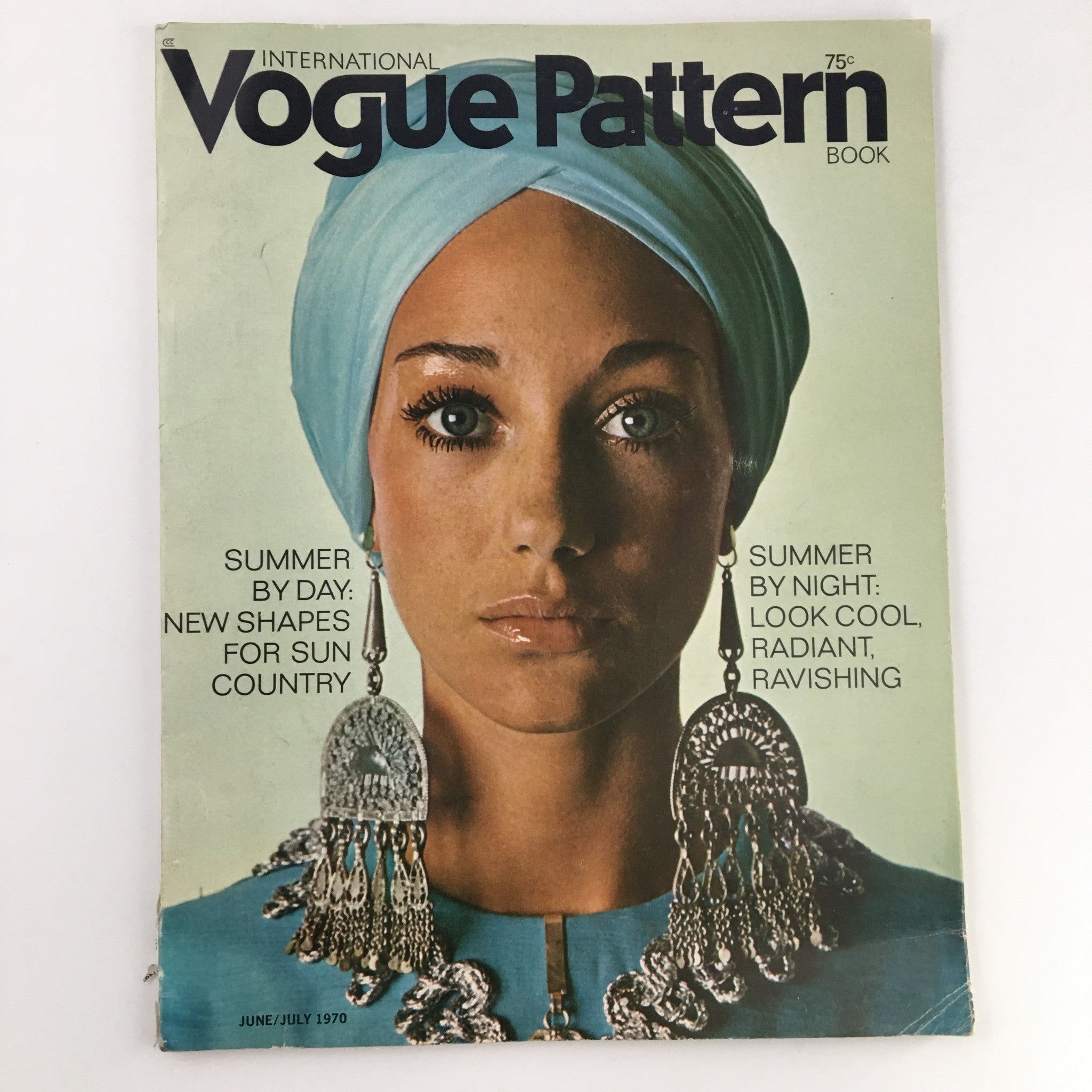 Cover of International Vogue Pattern Book June 1970 showcasing a model with a blue headscarf and ornate earrings, featuring the title 'Summer by Day: New Shapes for Sun Country.'
