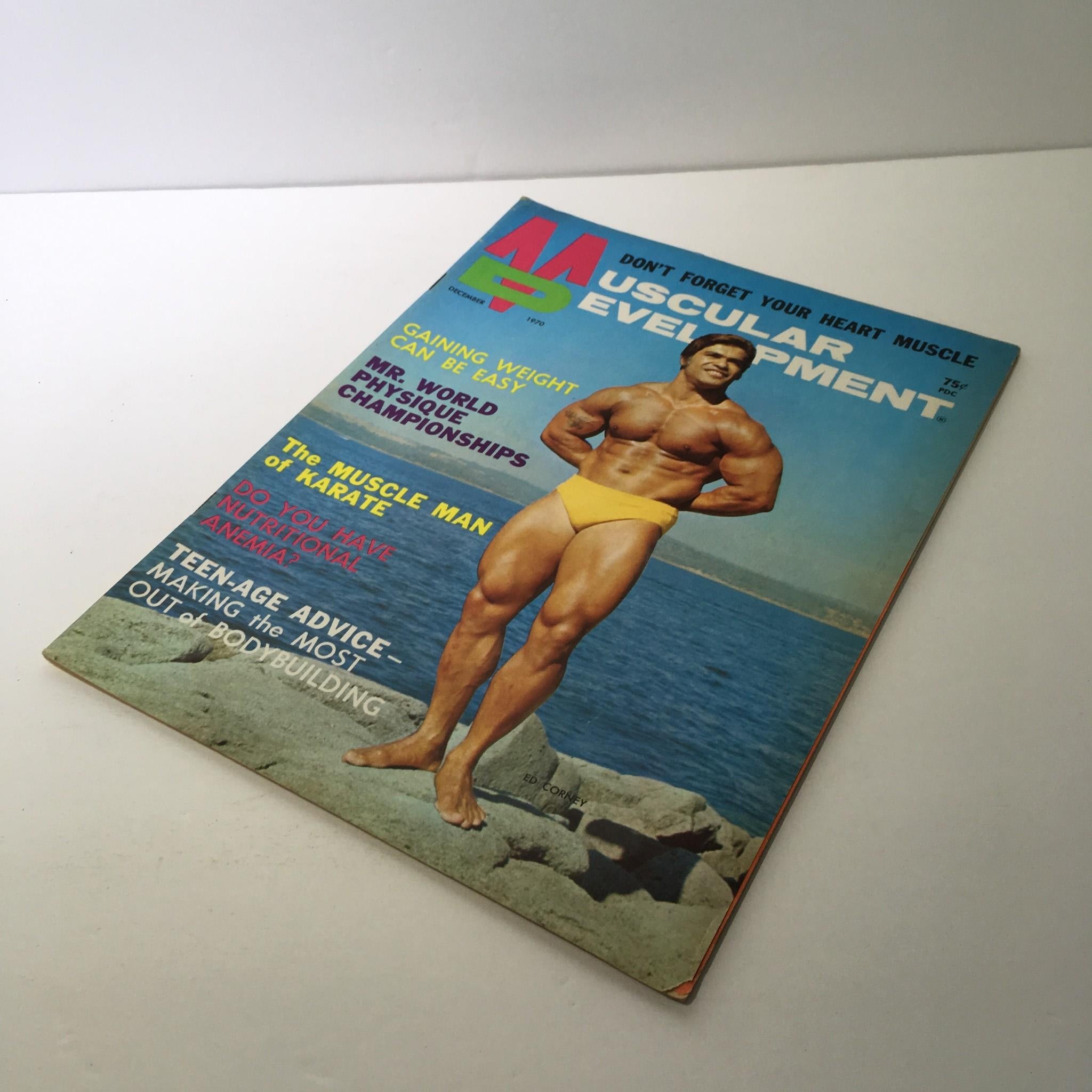 Cover of Muscular Development Magazine featuring Ed Corney, December 1970 issue, showcasing a muscular male figure in yellow swimwear by the beach with bold text promoting weight gain, Mr. World physique championships, and karate.