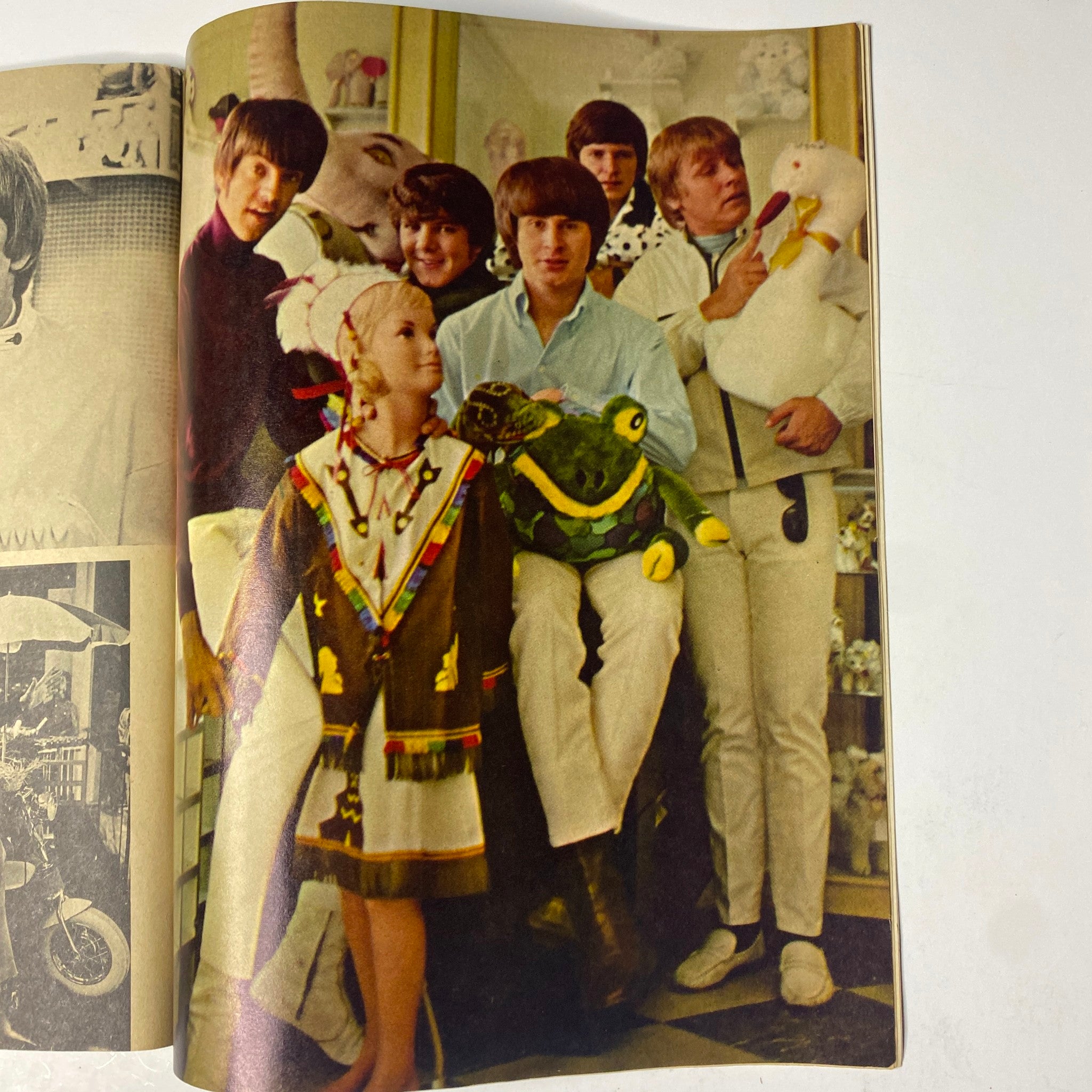 Vintage image from Teen Set Magazine December 1967 depicting The Monkees in a playful setting with a child. A joyful capture reflecting the era's pop culture.