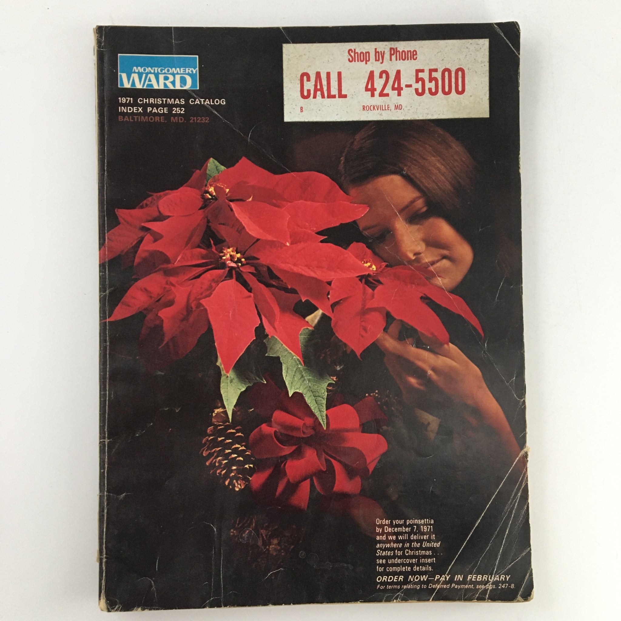 1971 Montgomery Ward Raggedy Dolls Christmas Price Guide Catalog cover featuring vibrant red poinsettias and a smiling woman, highlighting the holiday theme and vintage appeal.