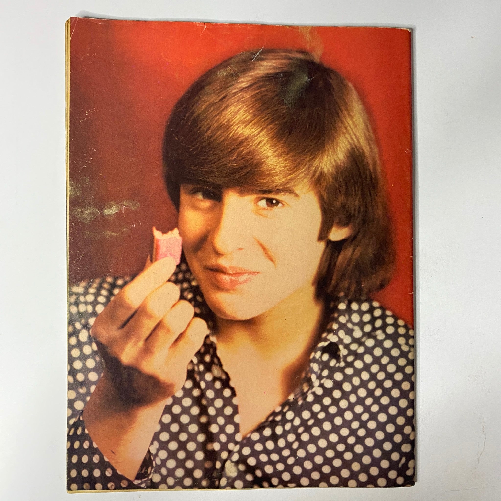 Close-up portrait of a young Monkees member from Tiger Beat's Official April 1967 #1 Monkee Spectacular holding a snack, capturing the essence of 1960s teen idol culture.
