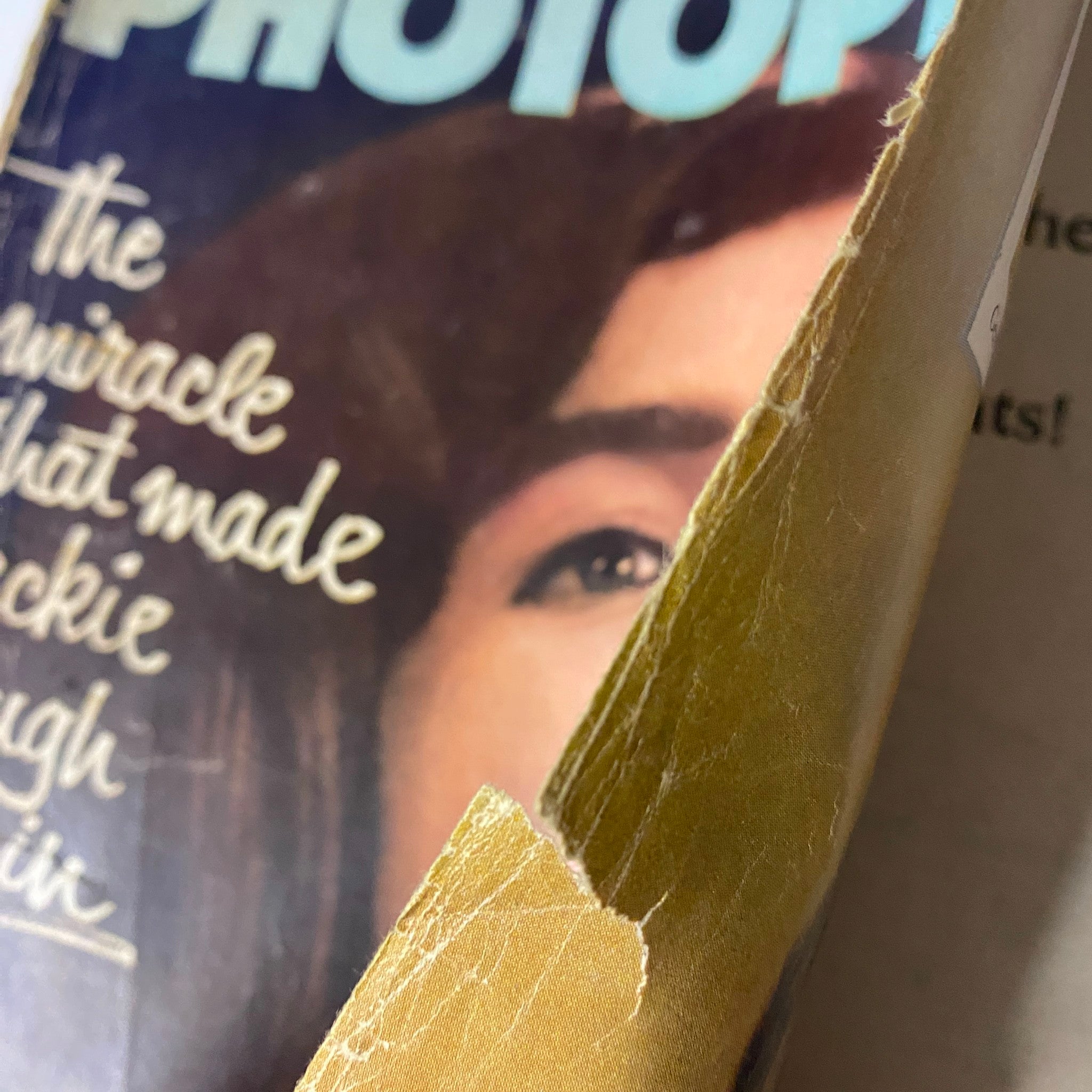 Detailed view of Photoplay Magazine July 1964 Vol 66 No. 1 showing wear and tear on the spine, featuring Jackie Kennedy on the cover with the headline referencing the article about her.
