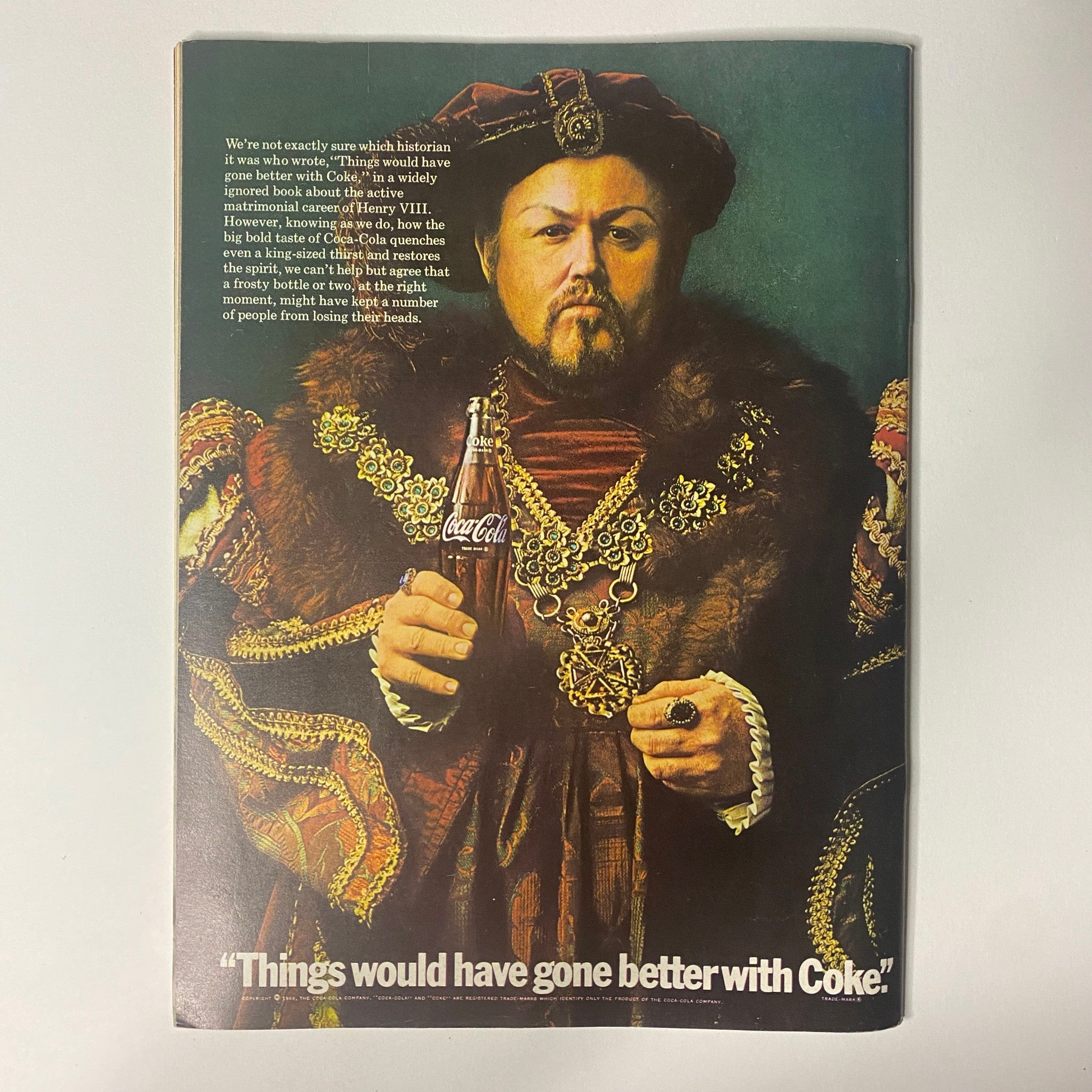 Vintage advertisement featuring a man dressed as Henry VIII holding a Coca-Cola bottle with the caption 'Things would have gone better with Coke'.