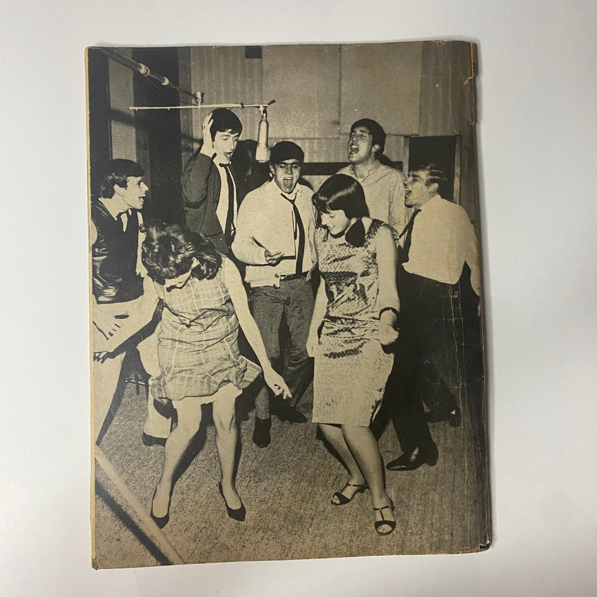 Back cover of 'Popular Annual Magazine 1964' featuring a lively scene with The Dave Clark Five and fans, capturing the energetic atmosphere of the 1960s British music scene.