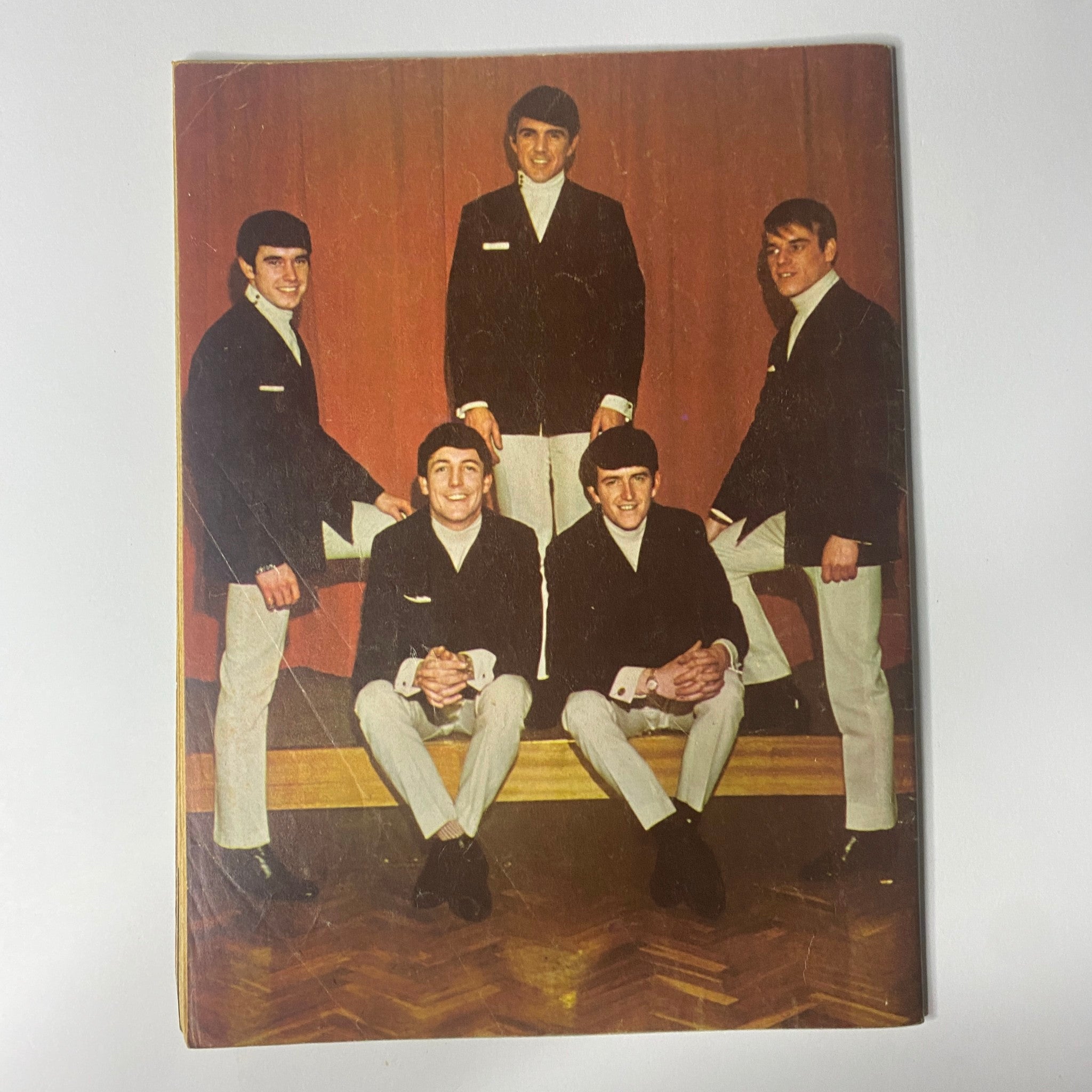Back cover of the 1964 Dave Clark Five Magazine featuring the band's members sitting together, reflecting the iconic style and imagery of the 1960s.