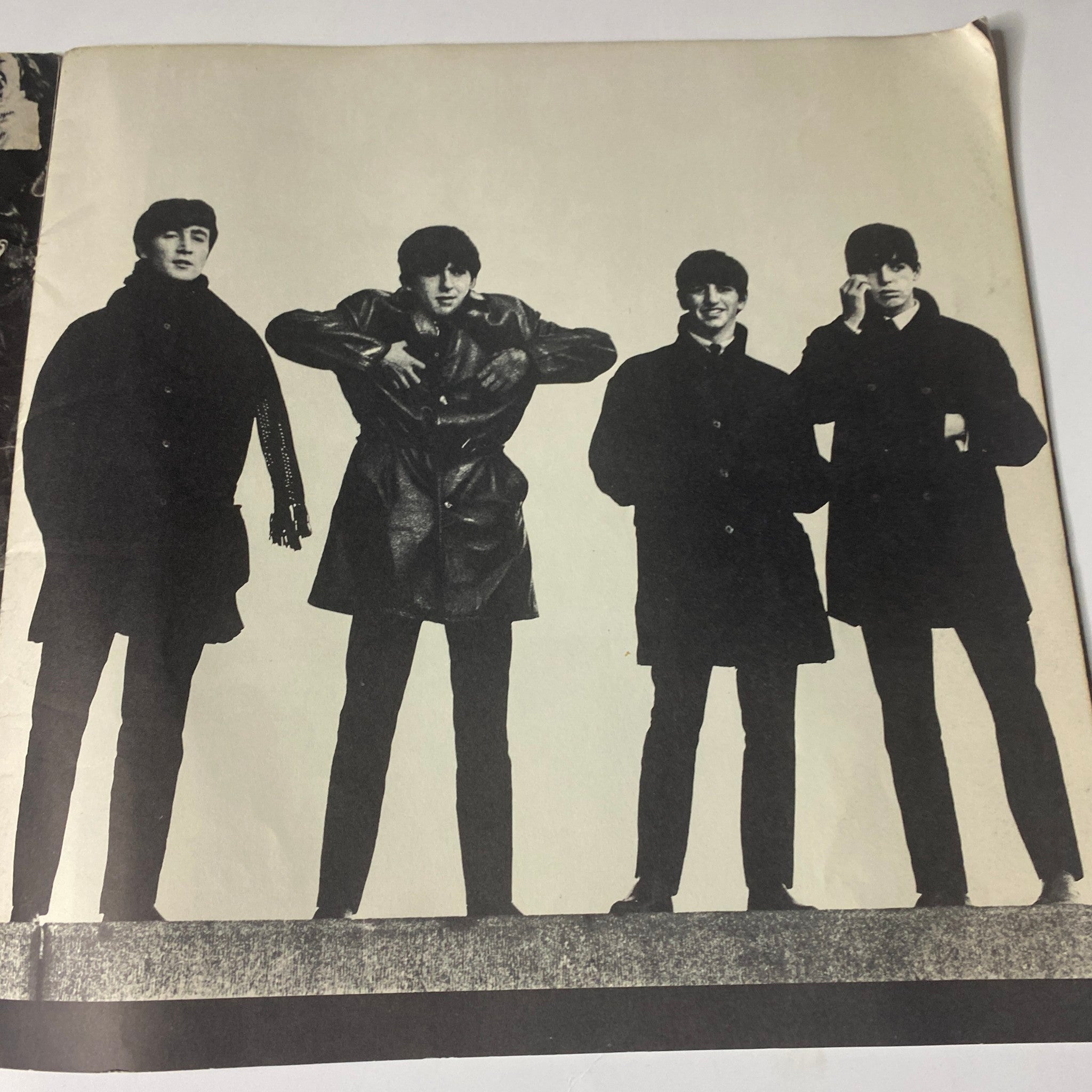 Photograph of the Beatles in casual poses included in the 1964 Beatles (U.S.A.) Ltd. Limited Tour Program Book, showcasing their iconic style.