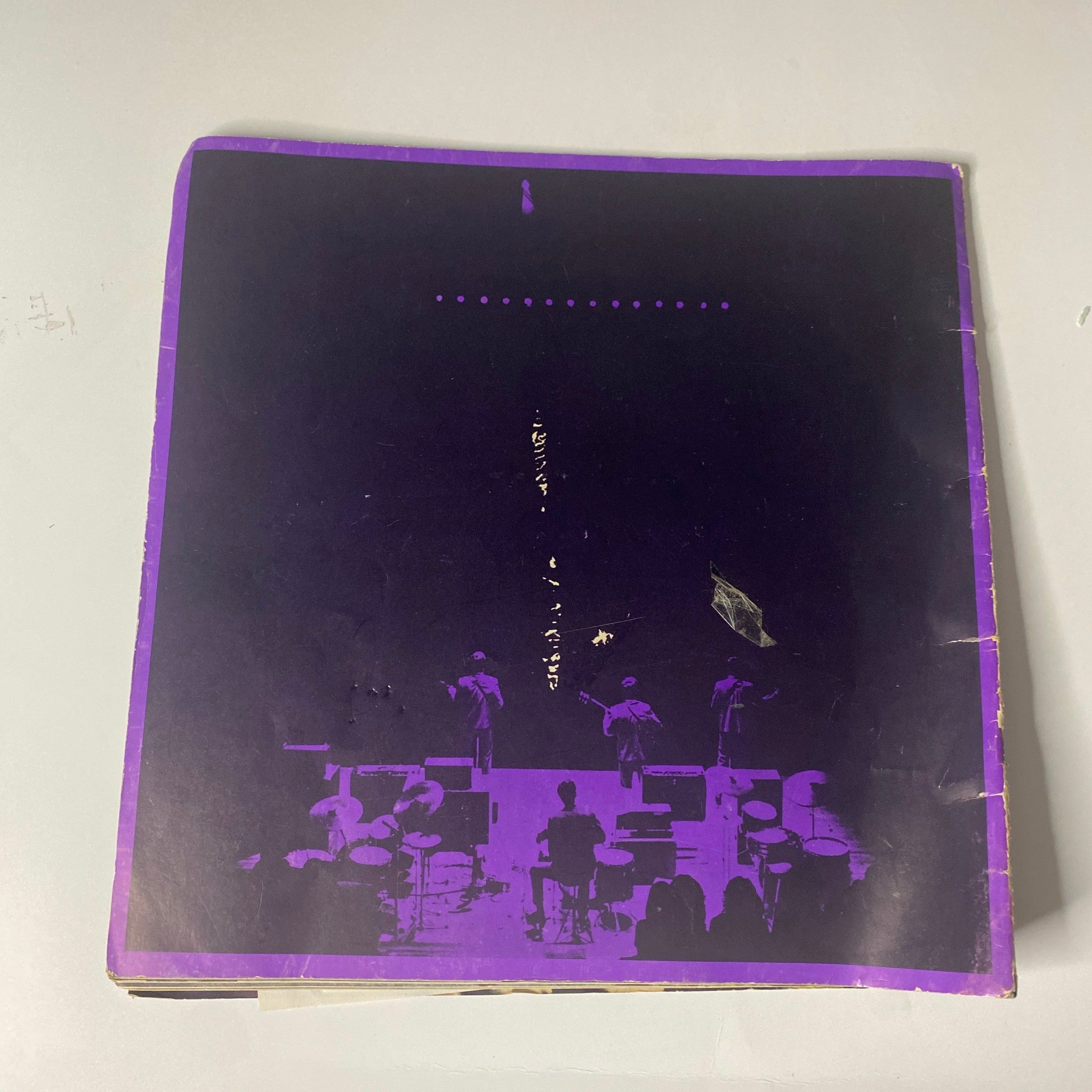 Back cover of the 1964 Beatles USA Limited tour program book highlighting a nostalgic purple design, featuring silhouettes of the band performing on stage.