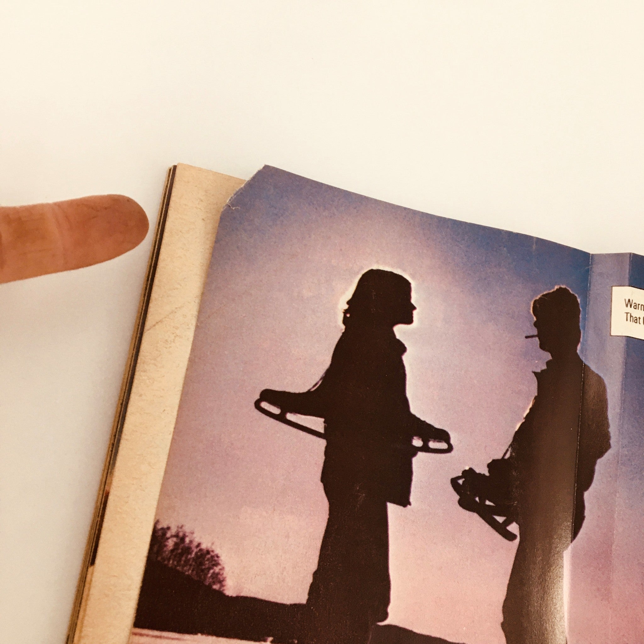 Silhouettes of two individuals holding ice skates from an advertisement in Sports Illustrated Magazine January 11 1982, reflecting retro lifestyle imagery.