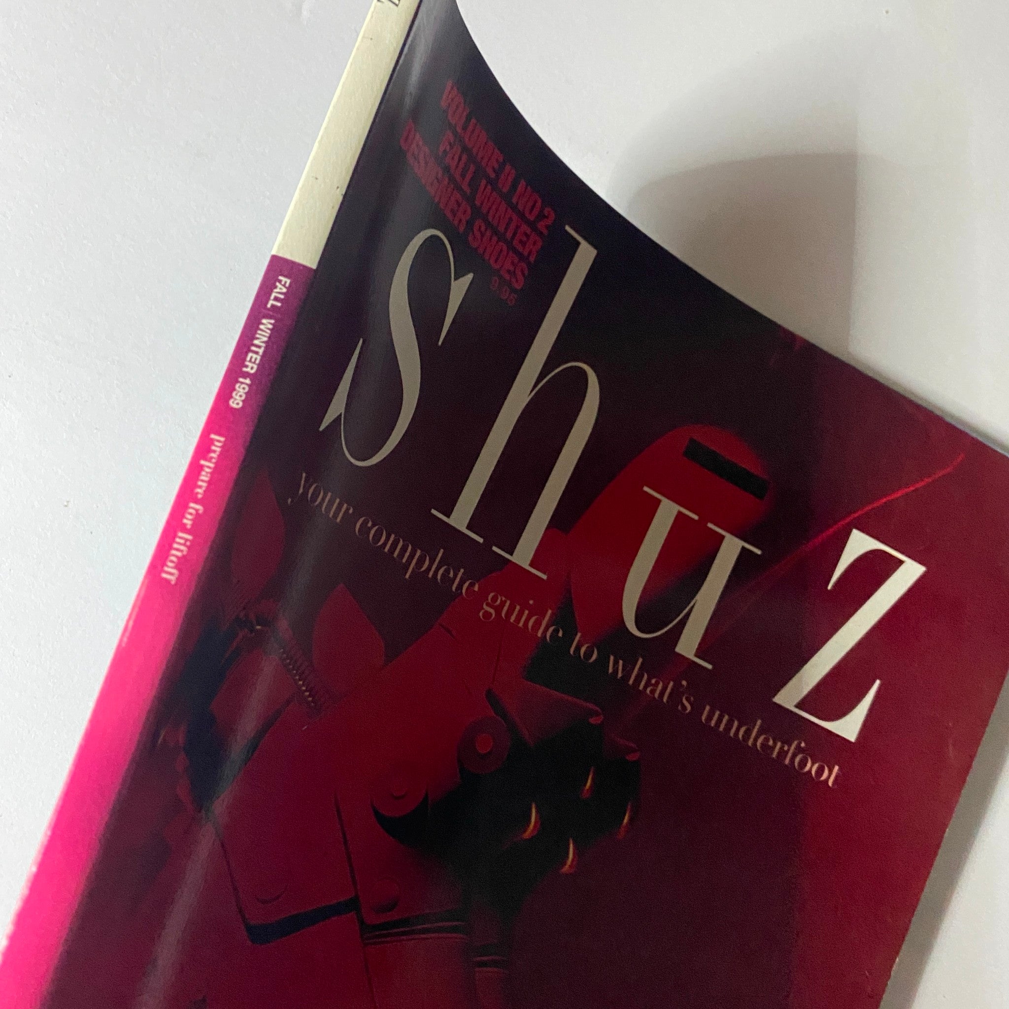 Close-up of the spine and cover of Shuz Magazine Fall / Winter 1999, Vol 2 No. 2, showcasing its vintage design elements and the title 'Prepare for Liftoff'.
