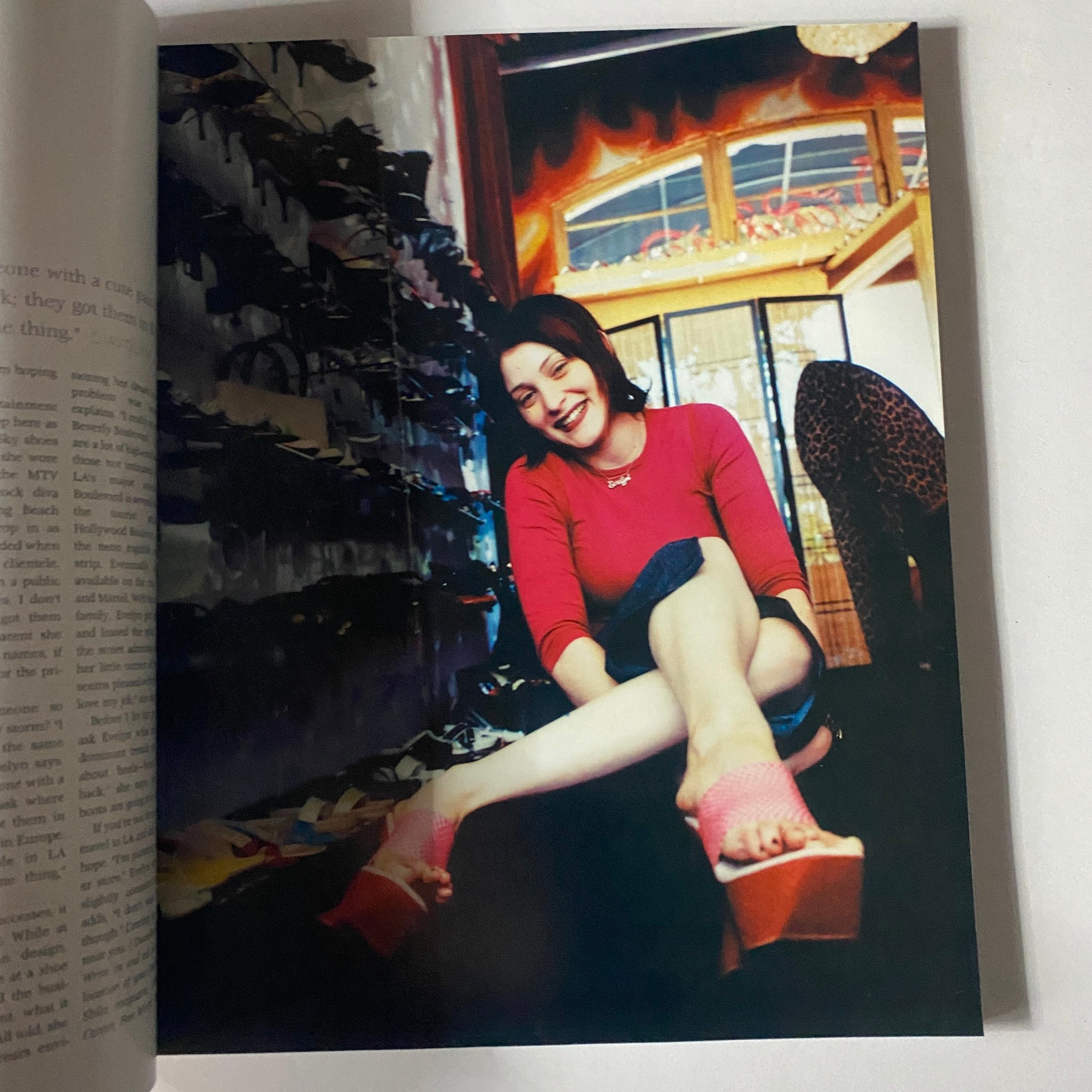 A joyful woman sitting in a shoe store featured in Shuz Magazine Fall / Winter 1999, Vol 2 No. 2, highlighting the fashion and vintage footwear of the era.