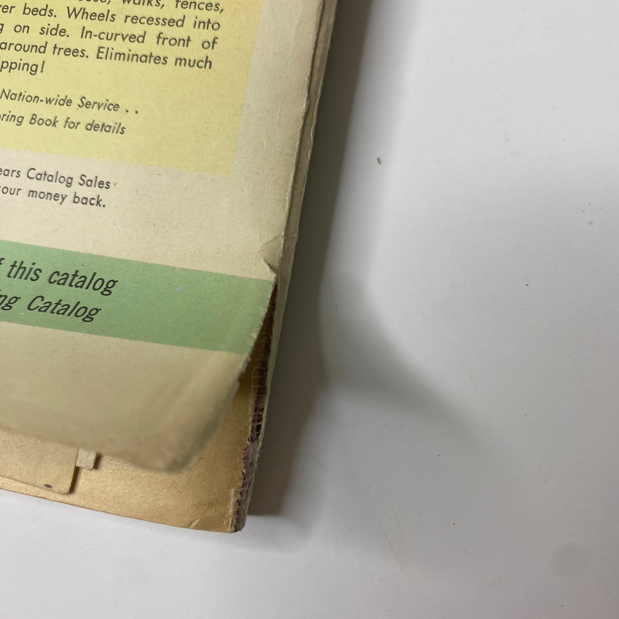 Close-up of the edge of the 1958 Sears Summer Sale Catalog showing faded vintage text and colors, emphasizing its collectible nature and historical significance.