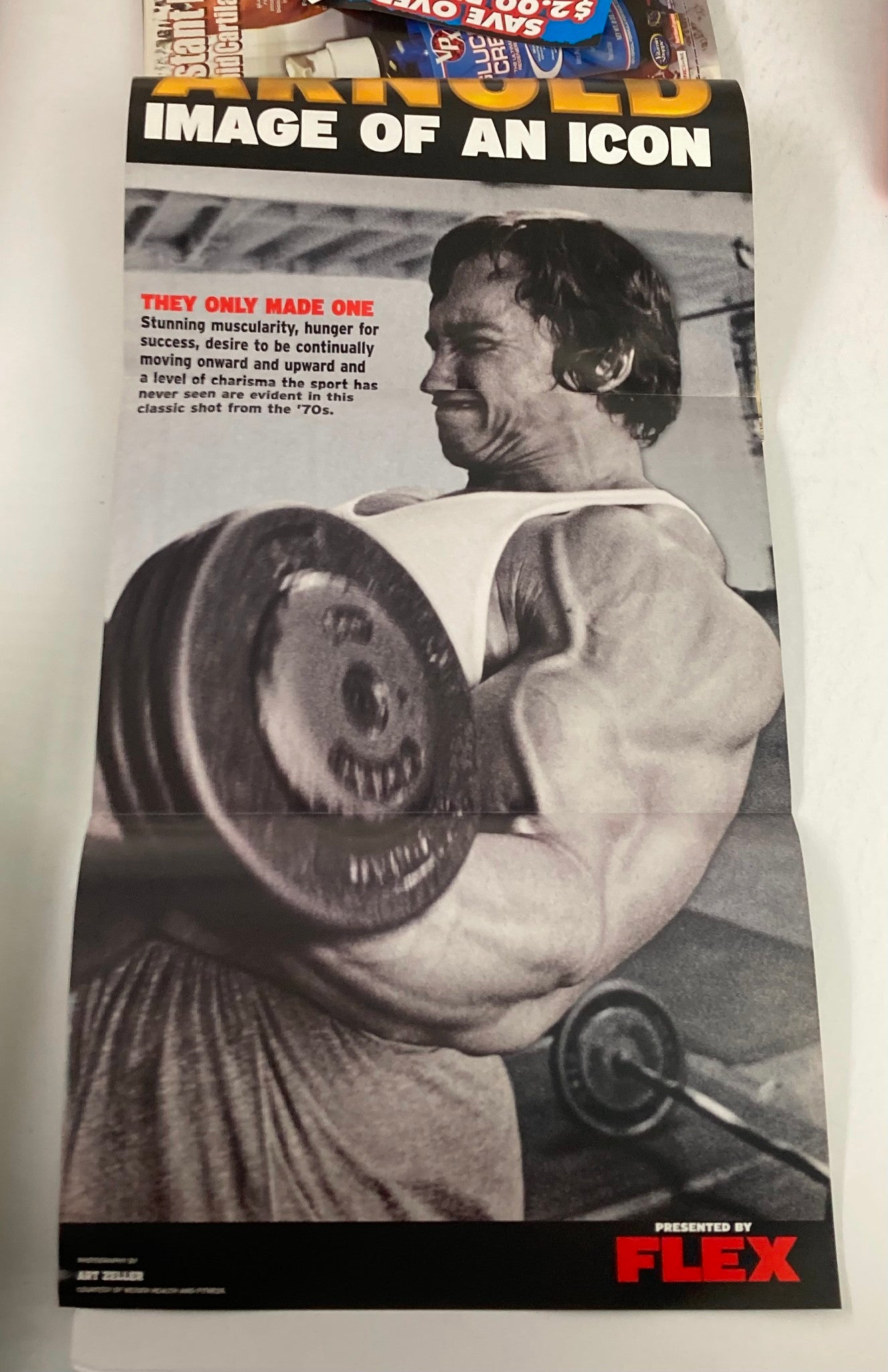 A poster from Flex Magazine, September 2004, Volume 22 #7, featuring Arnold Schwarzenegger lifting weights, highlighting the muscularity and dedication of bodybuilding culture.