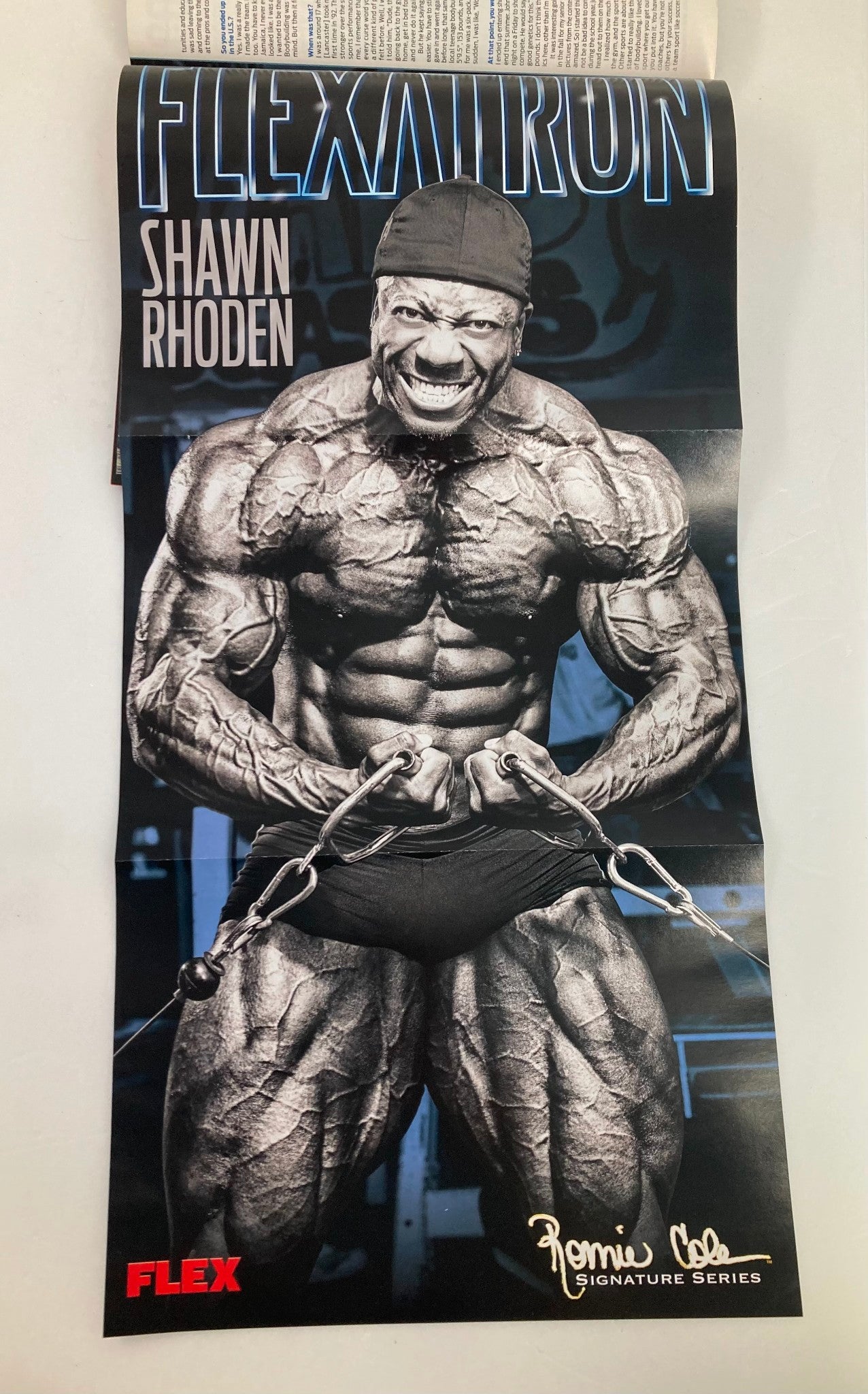 Flex Magazine July 2012 includes a poster of Shawn Rhoden, a renowned bodybuilder, displaying intense muscle definition while holding chains. A collectible item for bodybuilding enthusiasts.