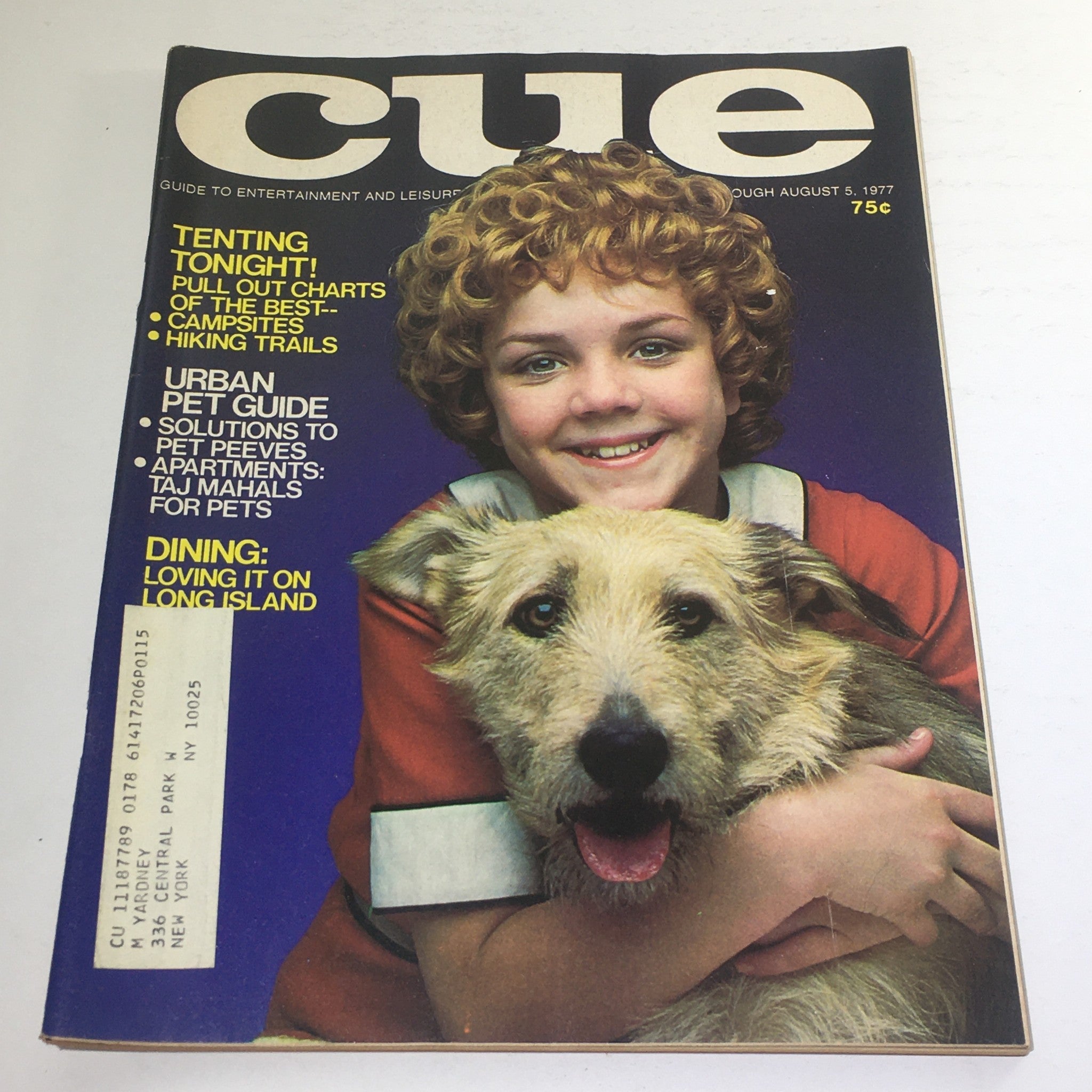 Cover of Cue Magazine: August 5 1977 featuring a young girl with curly hair smiling while holding a dog. The cover highlights articles about camping, pet care, and dining in Long Island.