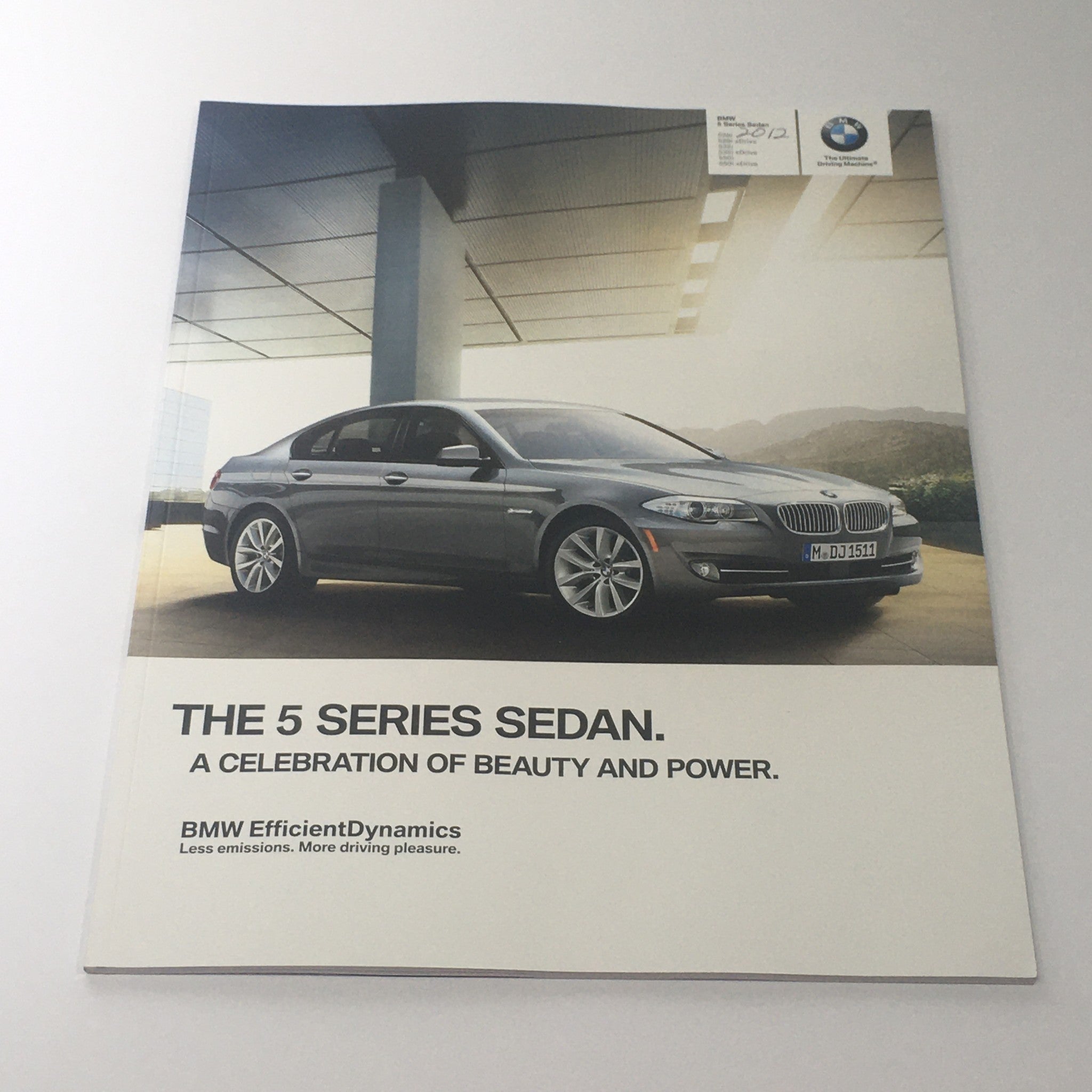 2012 BMW 5 Series Sedan brochure cover showcasing vehicle design, highlighting beauty and power.