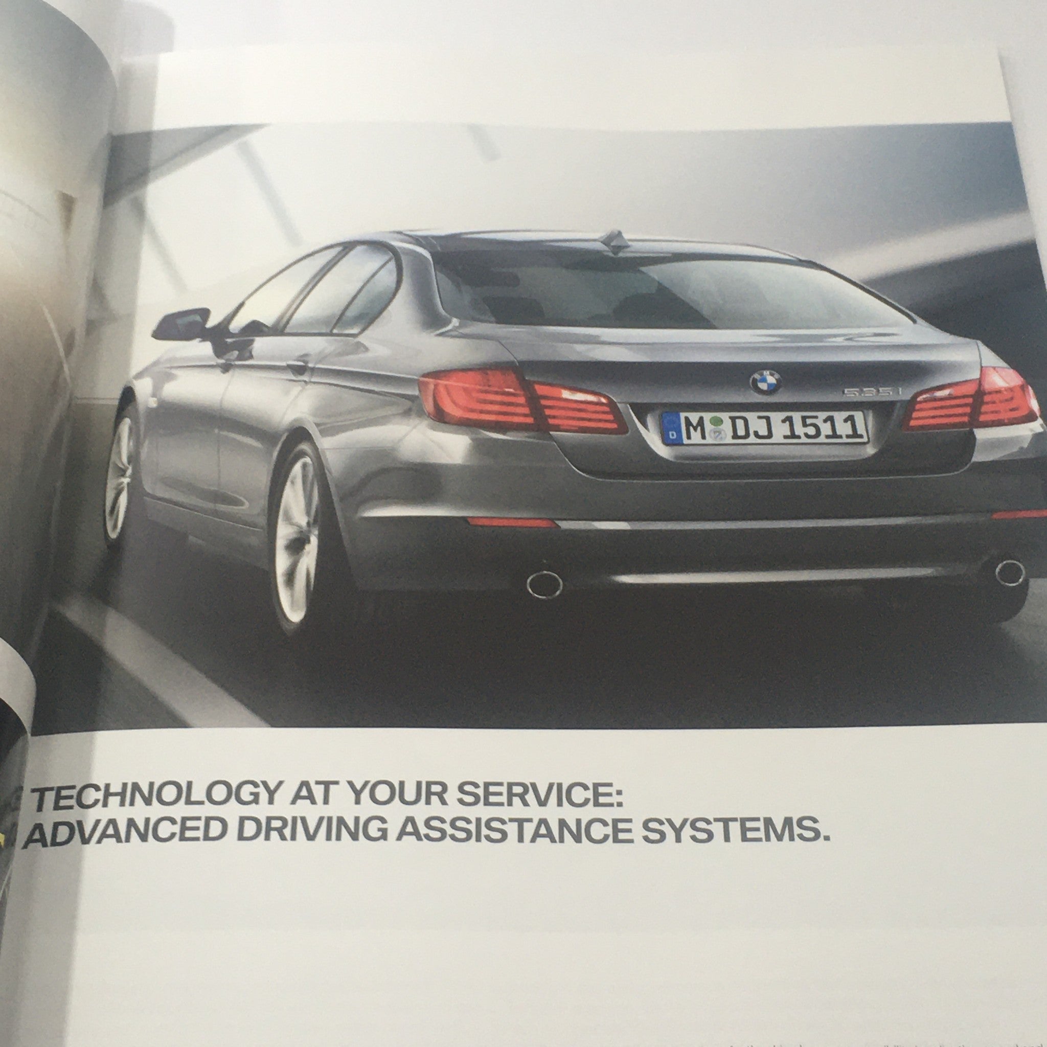Interior page of the 2012 BMW 5 Series Sedan brochure showing the rear view of the vehicle and technology details.
