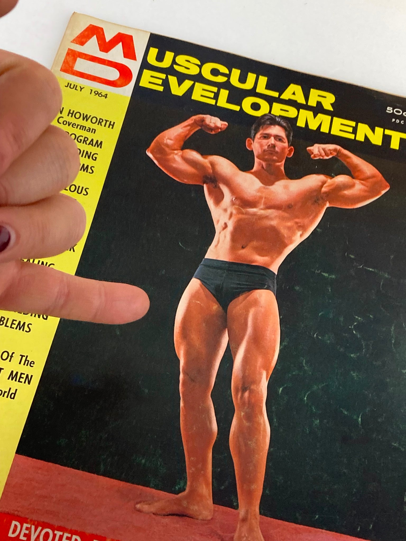 Close-up of the cover of VTG Muscular Development Magazine July 1964, highlighting bodybuilder Don Howorth and the magazine title.