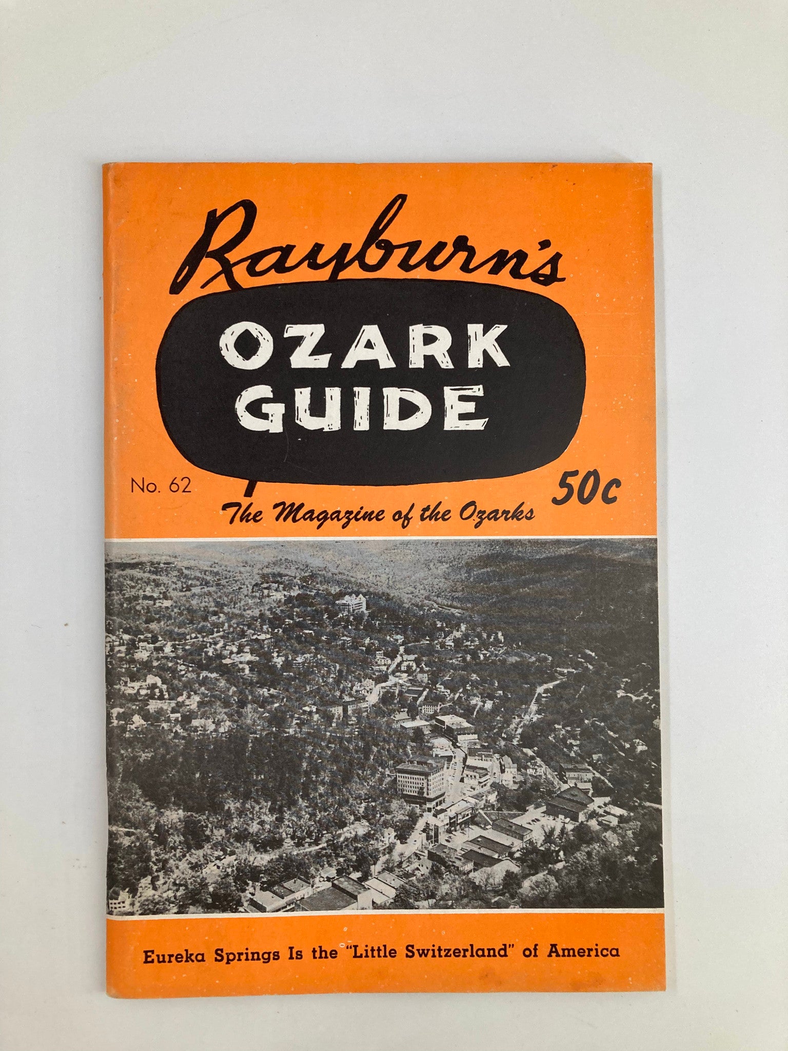 Cover of Rayburn's Ozark Guide Magazine, October 1959, featuring a vibrant orange design and an aerial view of Eureka Springs, showcasing the beauty of the Ozarks as 'The Little Switzerland of America.'