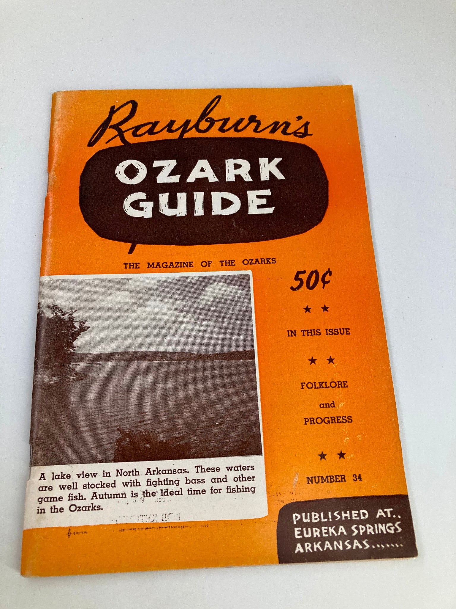 Rayburn's Ozark Guide Magazine Autumn 1952 cover featuring a lake view in North Arkansas, highlighting the magazine's vintage charm with an orange design and informative text about local fishing.