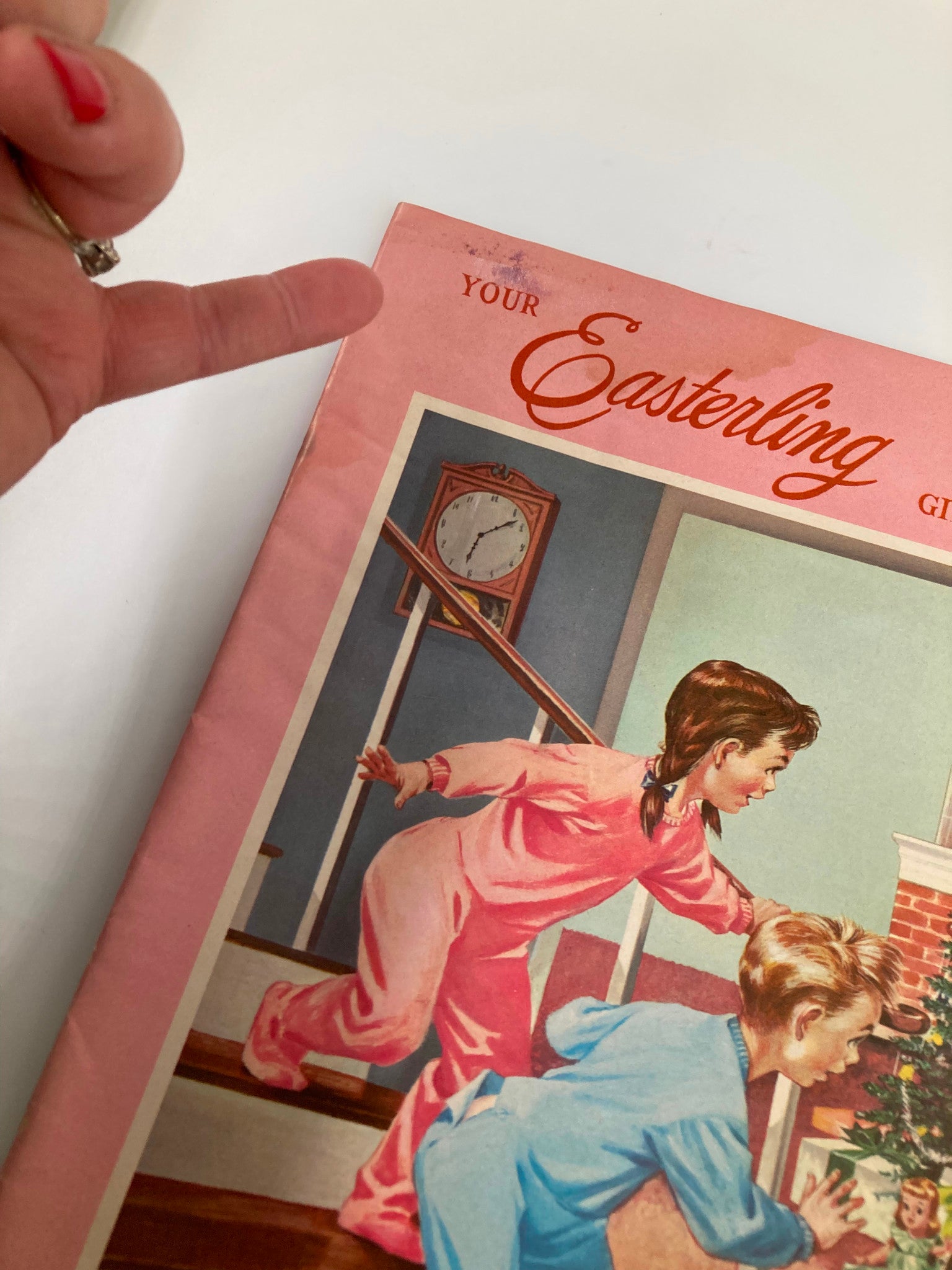 Close-up of the corner of the 1957 Easterling Gift Guide catalog, highlighting wear, showing children's anticipation for Christmas.