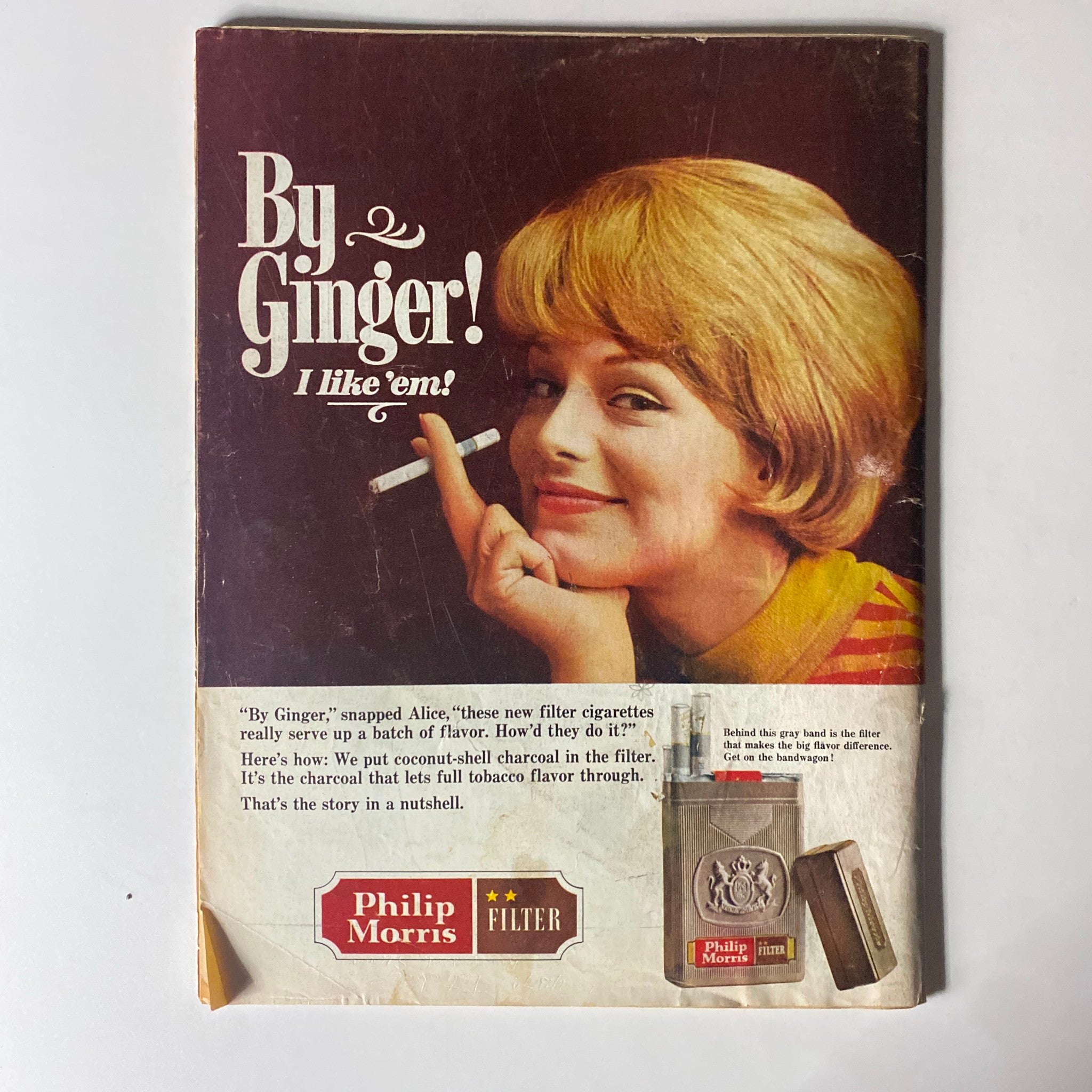 Vintage advertisement for Philip Morris cigarettes featuring a glamorous woman with a cigarette, captioned 'By Ginger! I like 'em!' showcasing 1960s cigarette marketing.