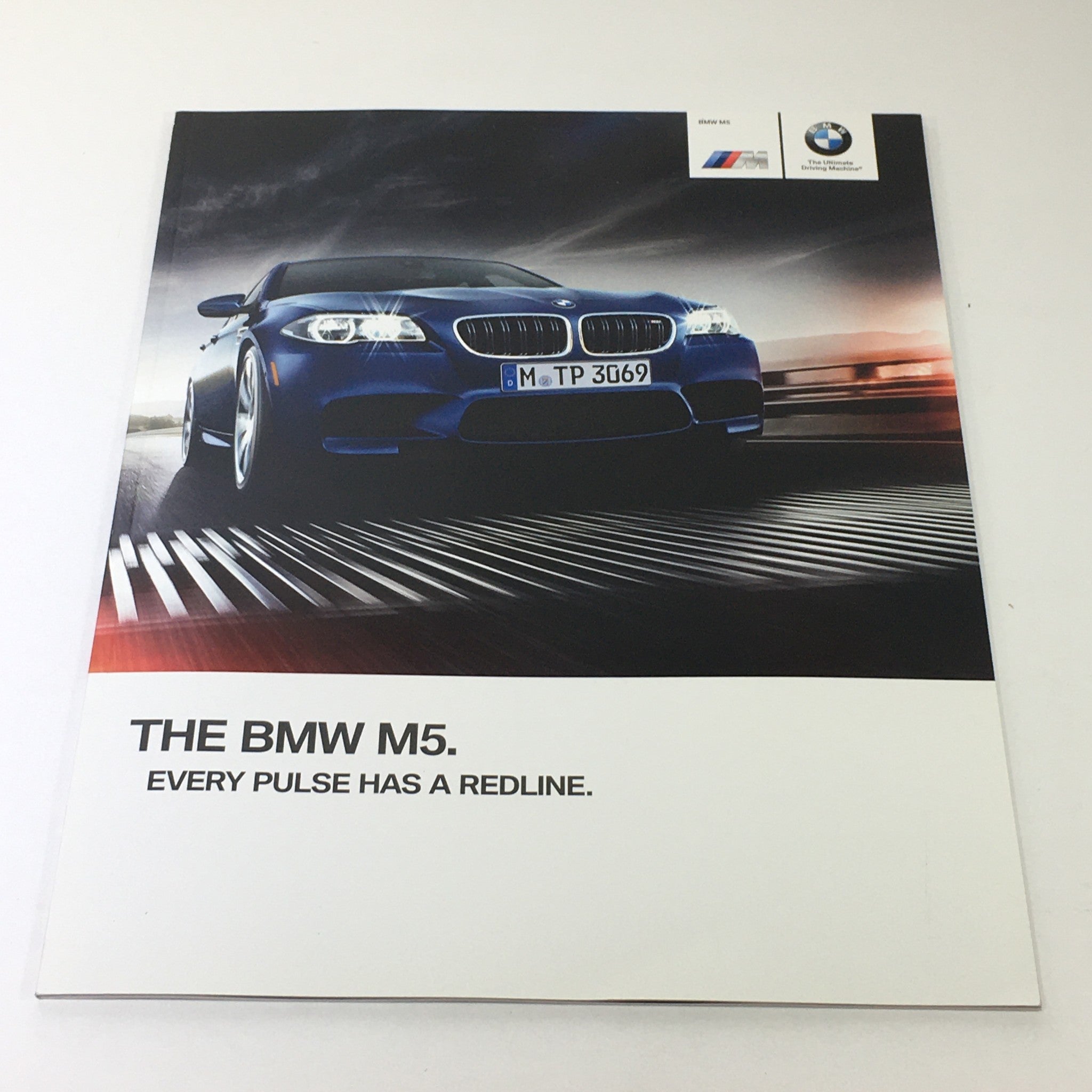 Cover of the 2014 BMW M5 Dealership Car Auto Brochure Catalog featuring a blue BMW M5 against a dramatic background, with the tagline 'Every Pulse Has a Redline'.