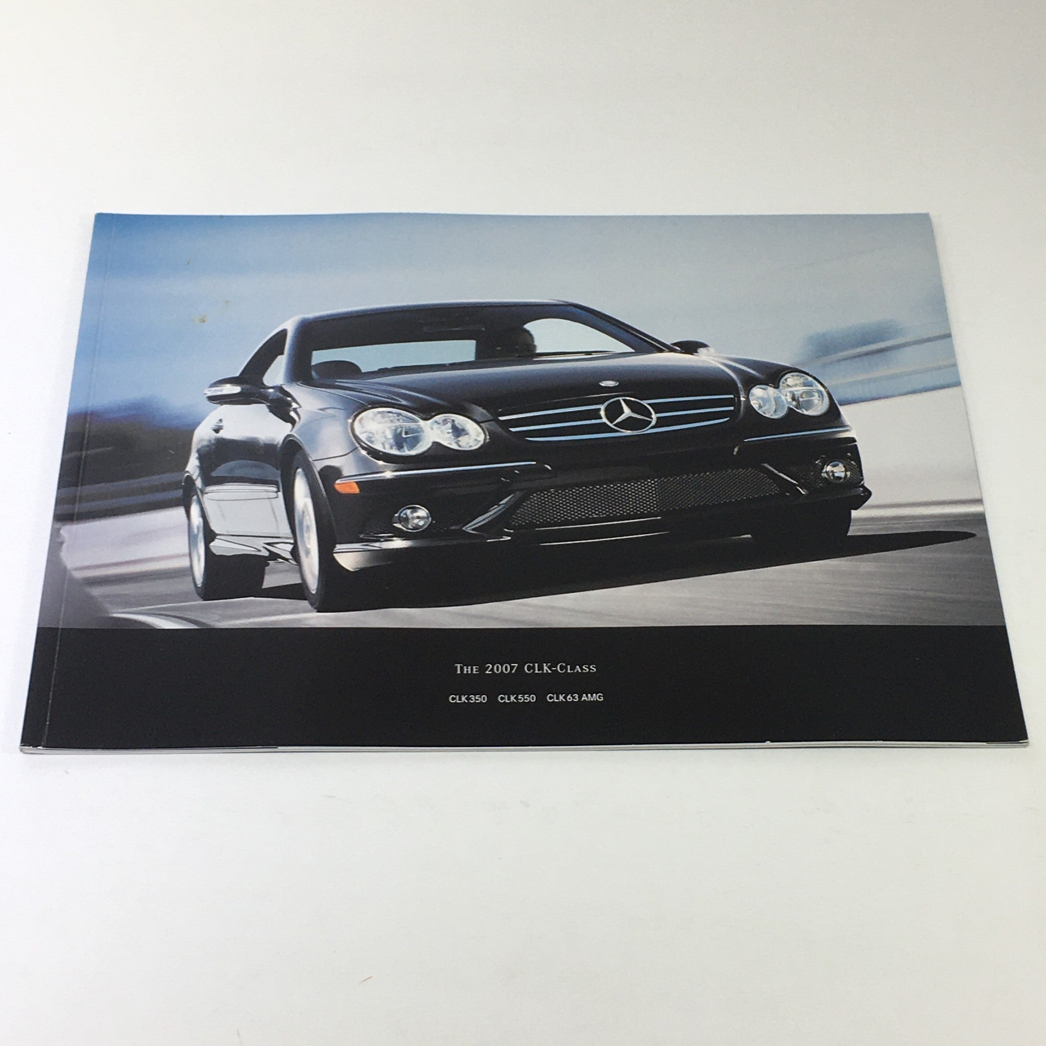 2007 Mercedes-Benz CLK-Class 350 550 63 AMG Dealership Car Auto Brochure Catalog showcasing a black Mercedes-Benz CLK-Class vehicle in motion, highlighting the sleek design and sporty appearance.