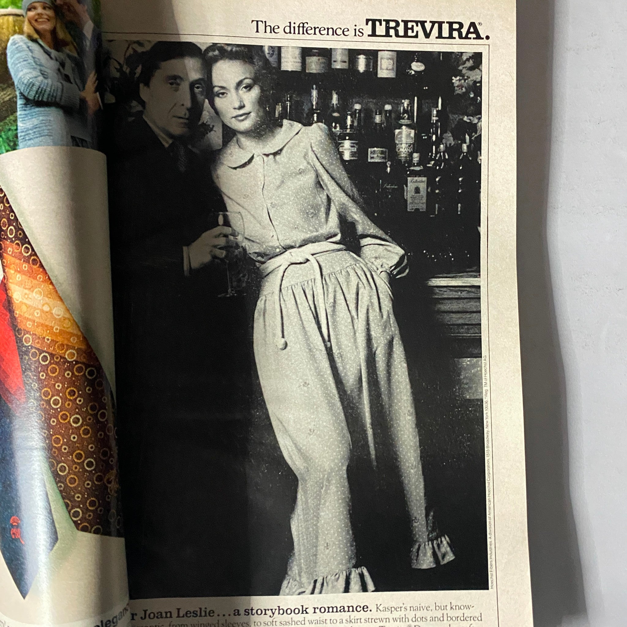 Black and white fashion advertisement from Harper's Bazaar Magazine December 1977 featuring a model in elegant attire with a striking drink in hand.