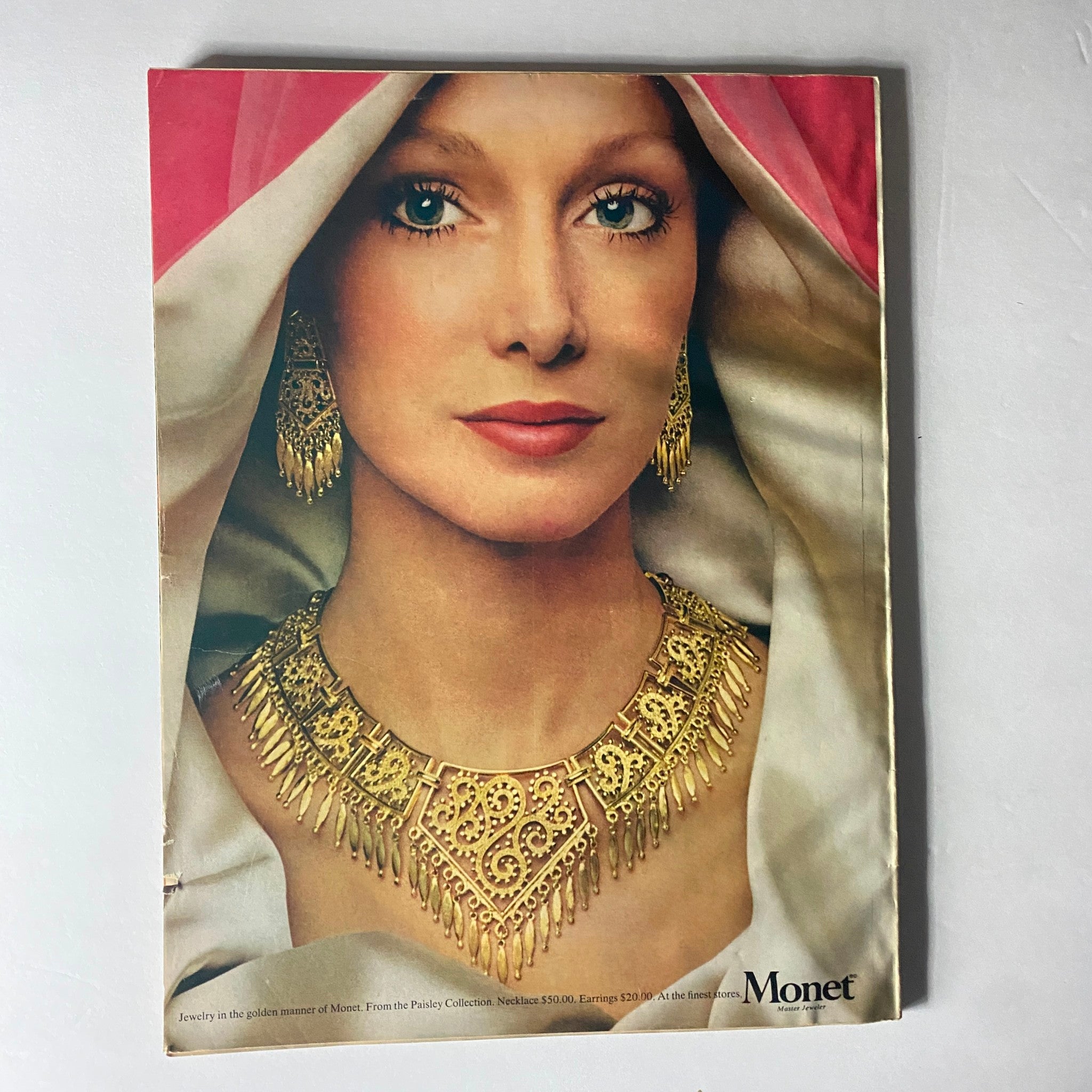 Back cover of Harper's Bazaar Magazine February 1973 showcasing a model wearing stunning jewelry from Monet, emphasizing fashion trends and accessories of the era.