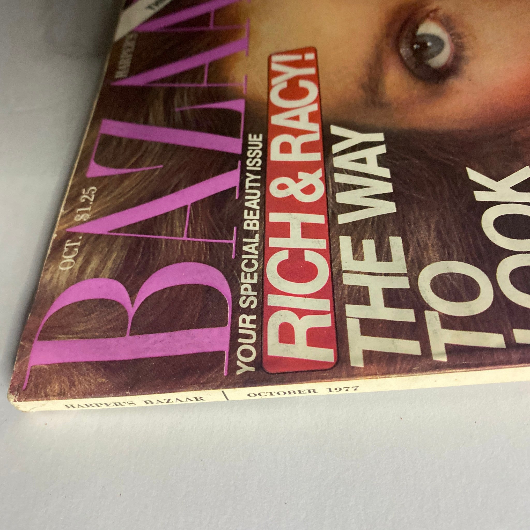 Close-up angle of Harper's Bazaar Magazine, October 1977, showcasing the magazine's title and bold headlines about beauty trends and fashion styles.
