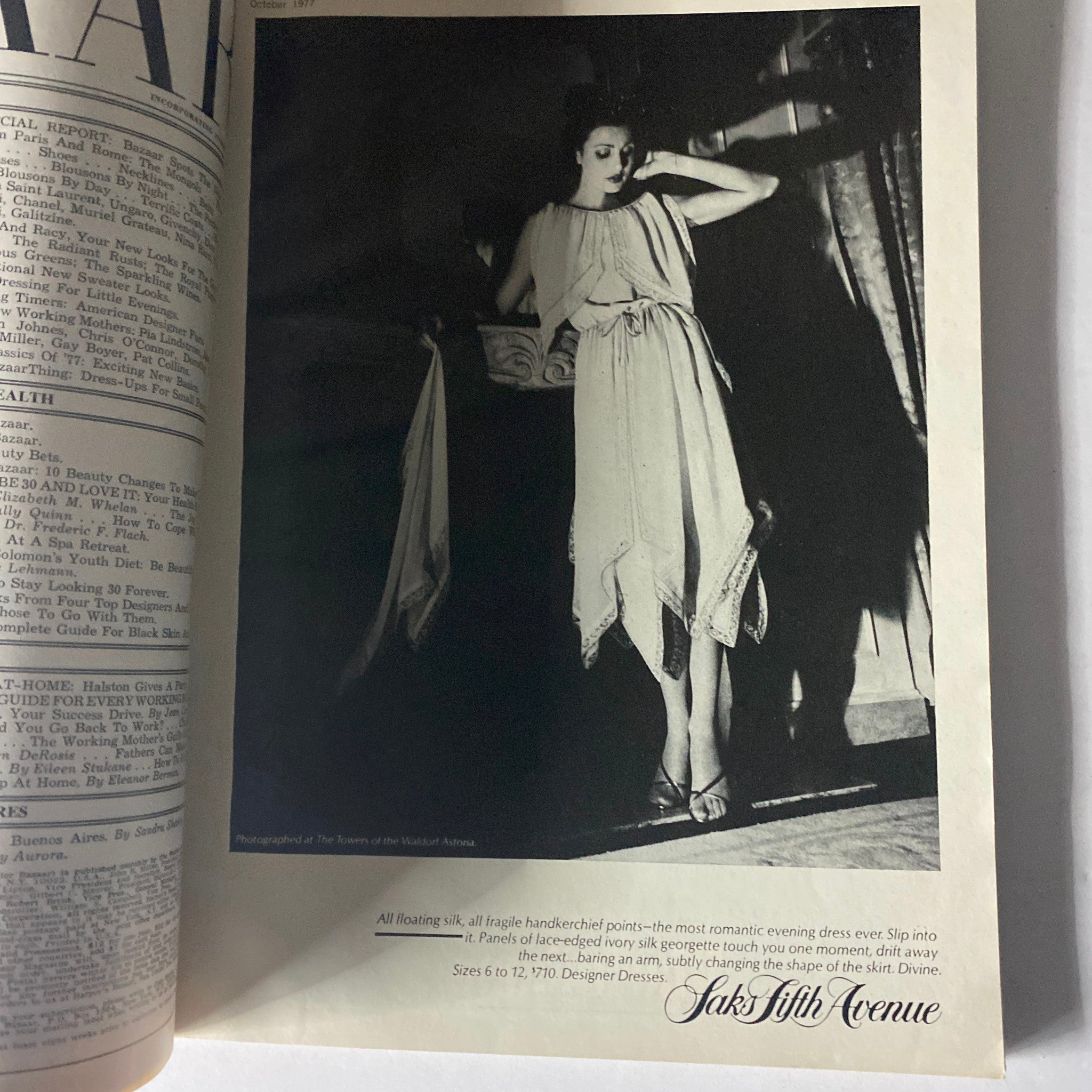 An elegant fashion advertisement inside Harper's Bazaar Magazine, October 1977, displaying a flowing silk evening dress from Saks Fifth Avenue.