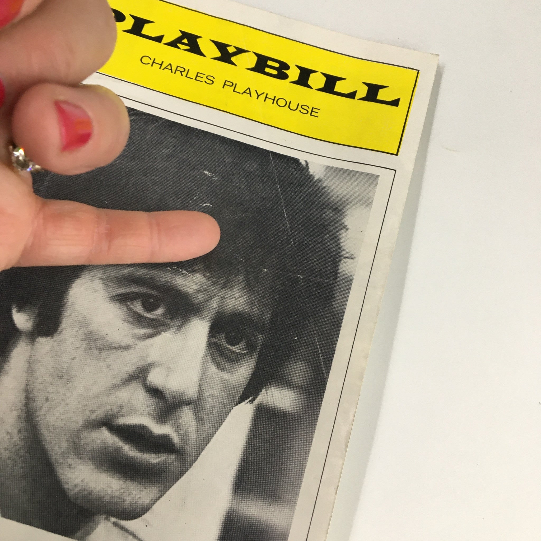 Close-up of the 1975 Playbill for 'Arturo Ui' with Al Pacino, showcasing a hand gesture pointing at the cover.