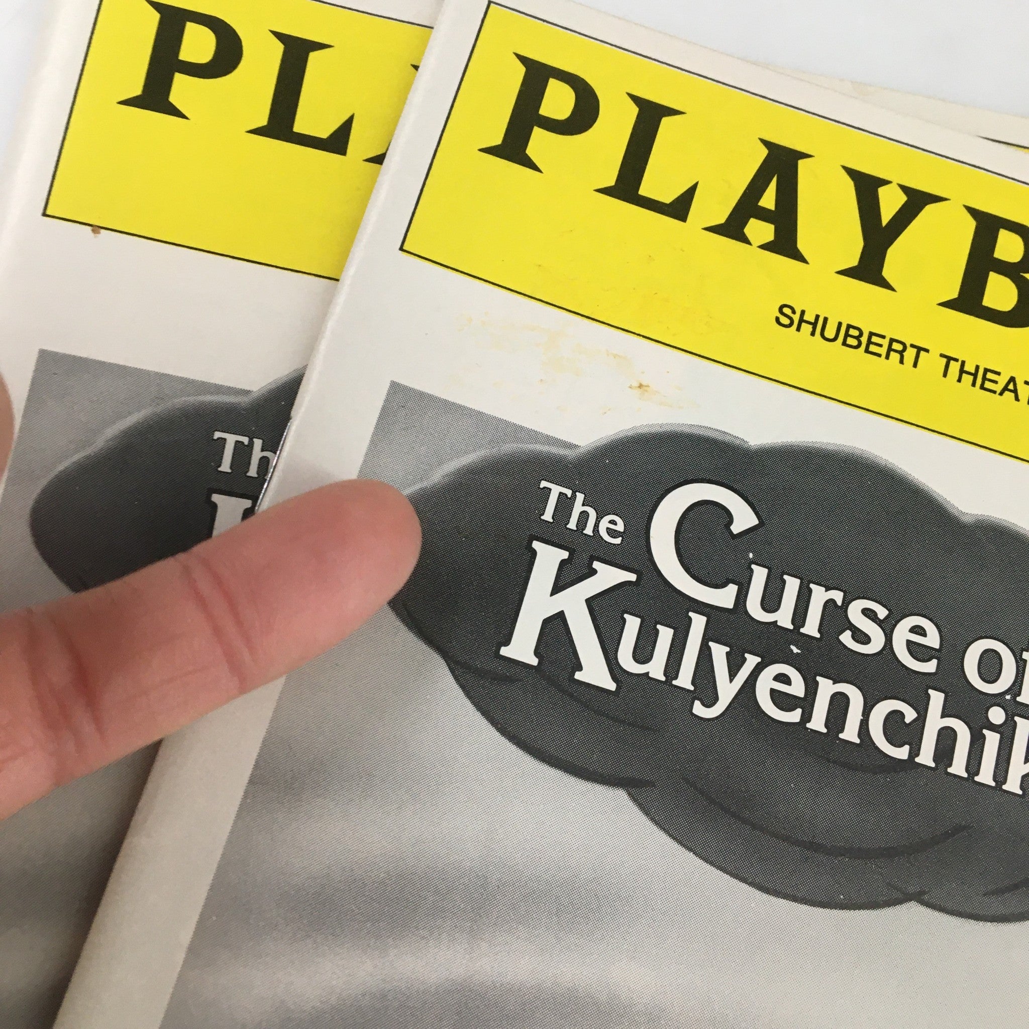 Close-up of two 1981 Playbills for 'The Curse of Kulyenchikov', highlighting the distinct yellow logo and cloud graphic.