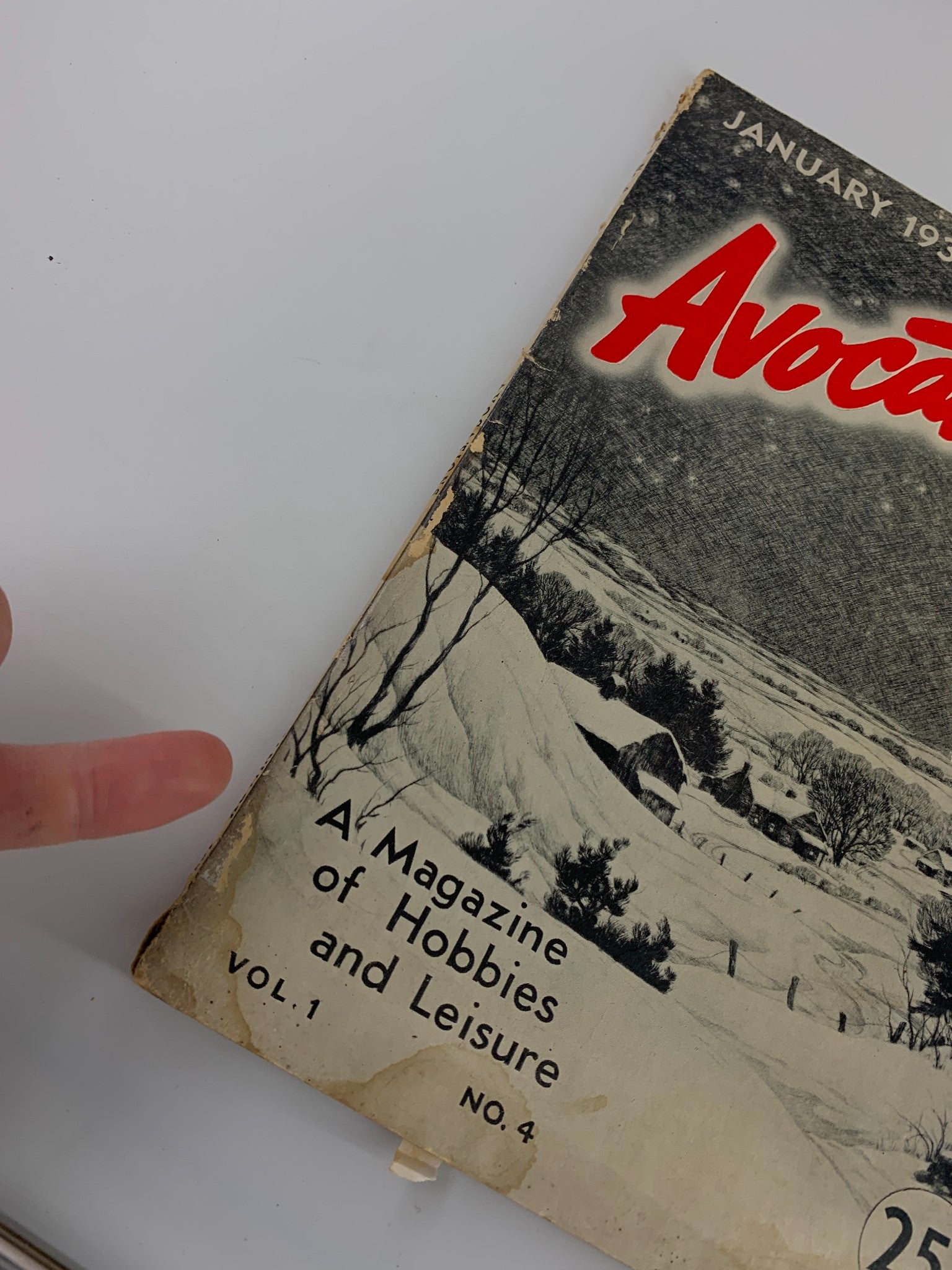 Close-up of the cover of VTG Avocations Magazine January 1938, highlighting the title and the snowy landscape with a finger pointing at the text.