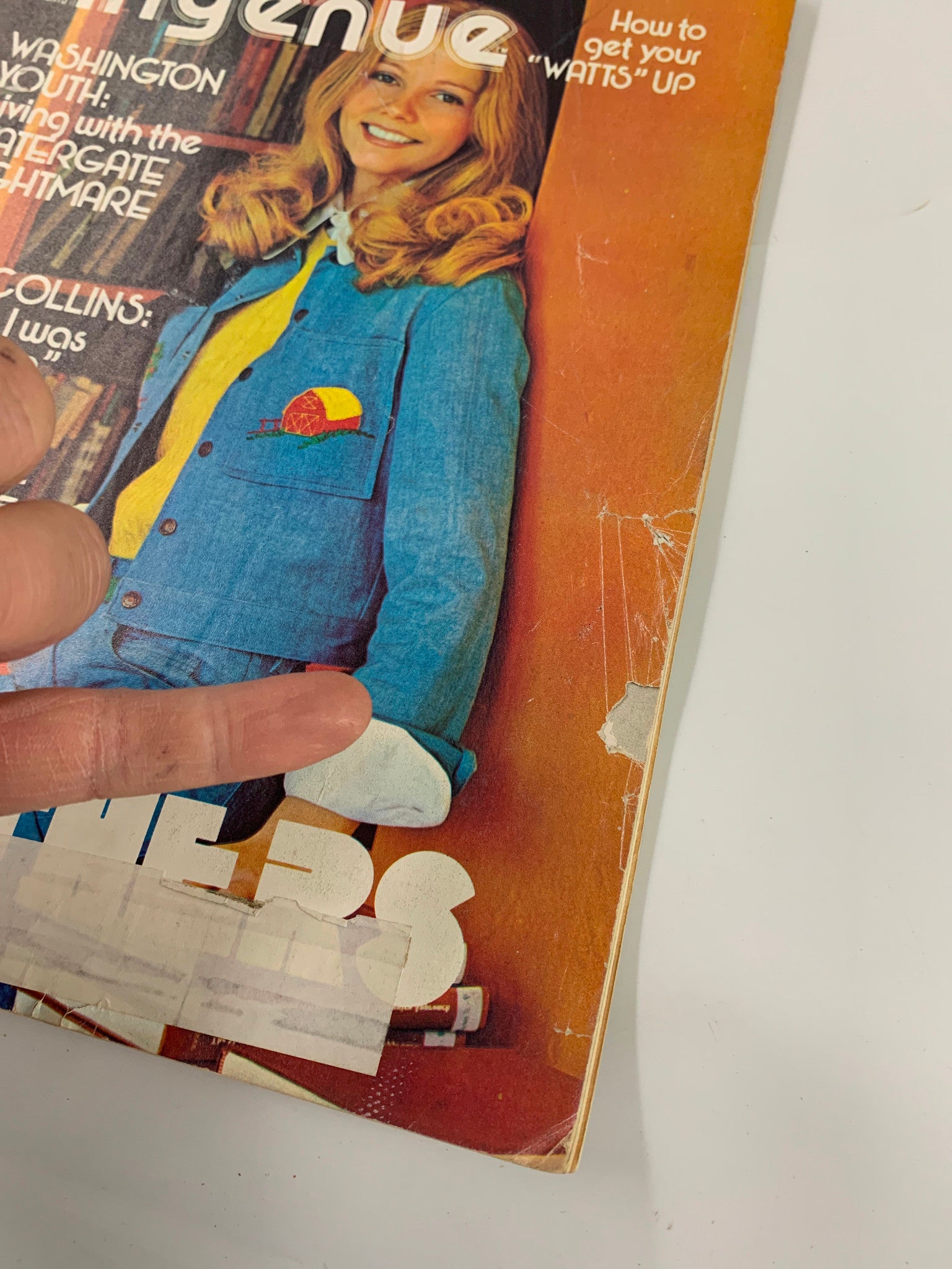 Close-up of the cover of the VTG New Ingenue Magazine February 1974, highlighting the smiling model and text related to Judy Collins and Jim Croce, with visible wear consistent with its vintage status.