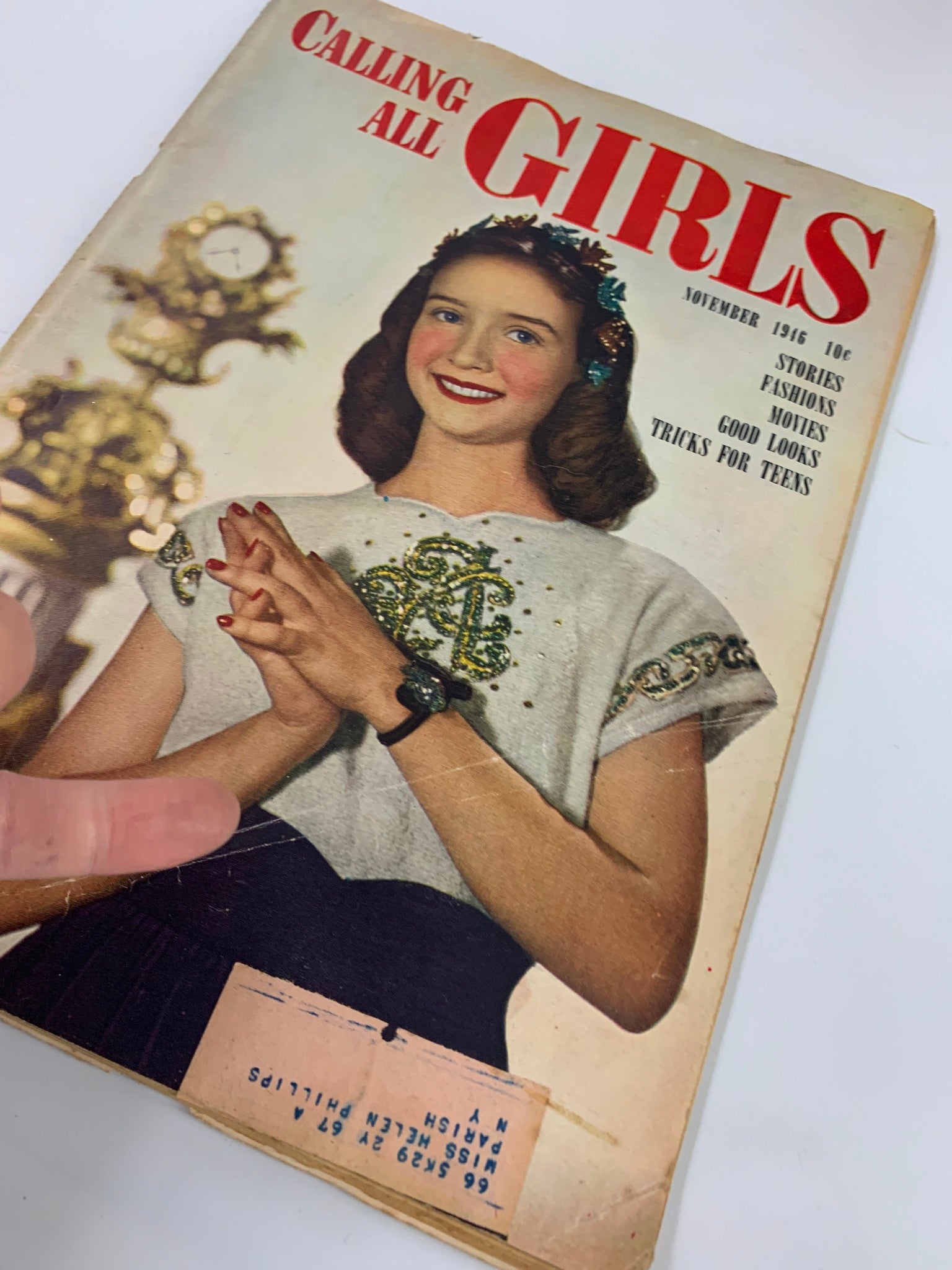 Close-up view of VTG Calling All Girls Magazine November 1946 cover with a thumb resting on it, highlighting the charming portrait of a girl and the magazine's details.