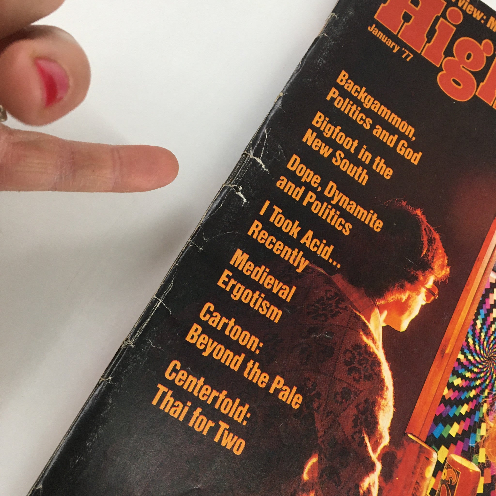 Close-up of VTG High Times Magazine January 1977 cover showcasing the content list, including articles about politics, LSD, and cannabis culture, and the prominent interview with Michael Kennedy.
